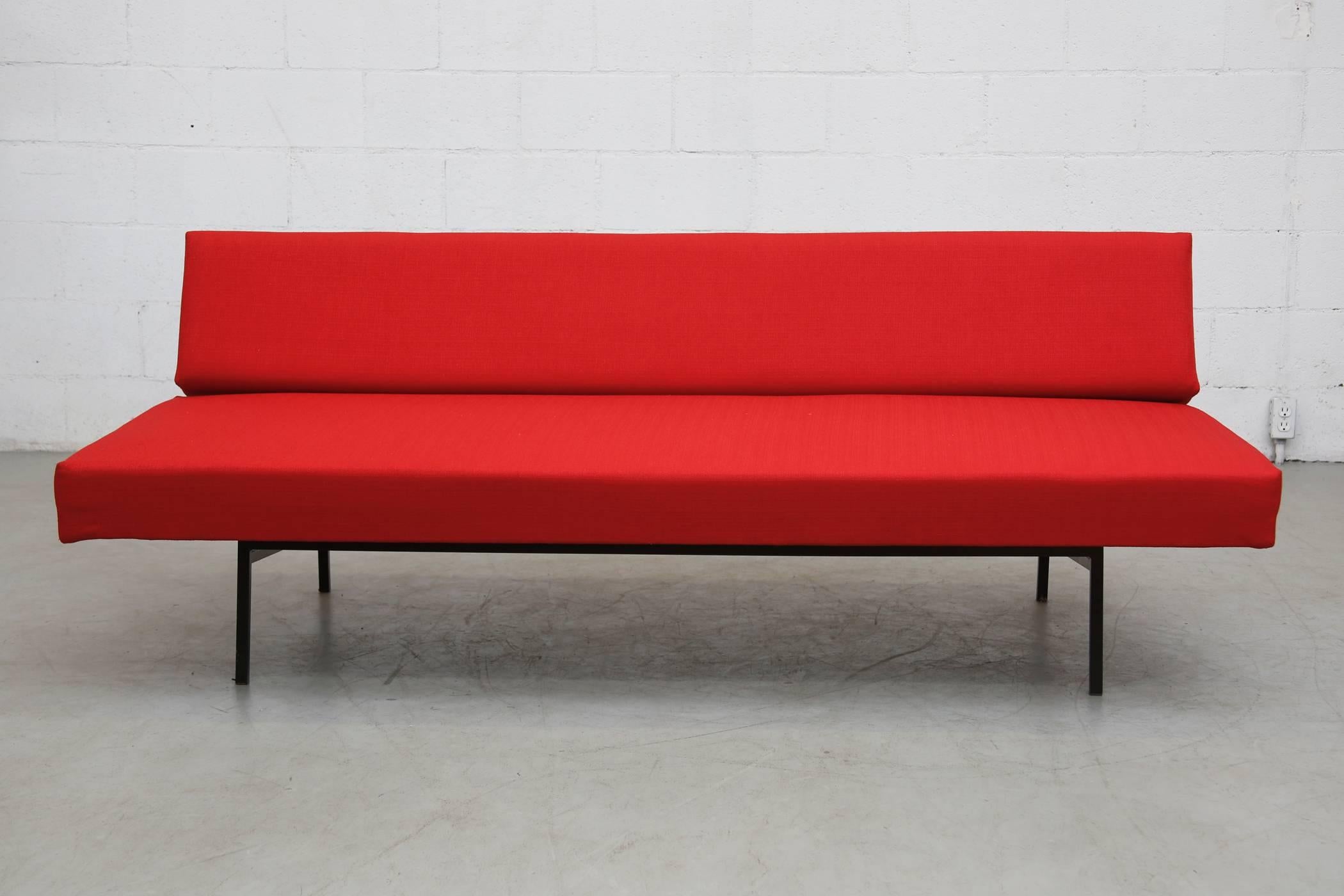 Beautiful Gijs Van Der Sluis designed, mid-century sleeper sofa with enameled black metal frame. Recently upholstery in fire red. The bottom pulls away from seat back to level out and become a daybed! Frame in original condition with some wear