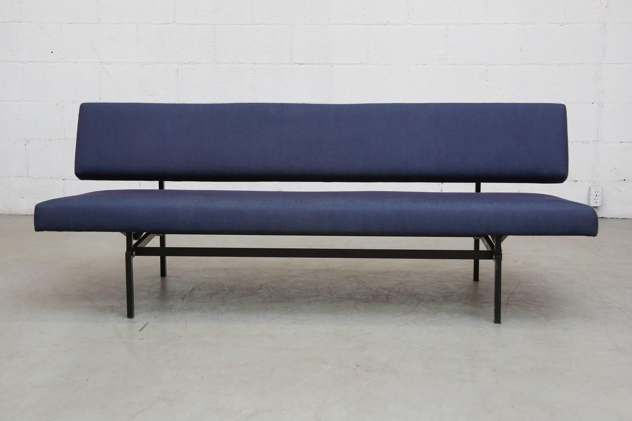 Navy upholstered Martin Visser sleeper sofa with pull-out bench that levels to a single bed for your guest. Fabric has faded stripe on upholstery, frame in good original condition with wear consistent with age and use.
