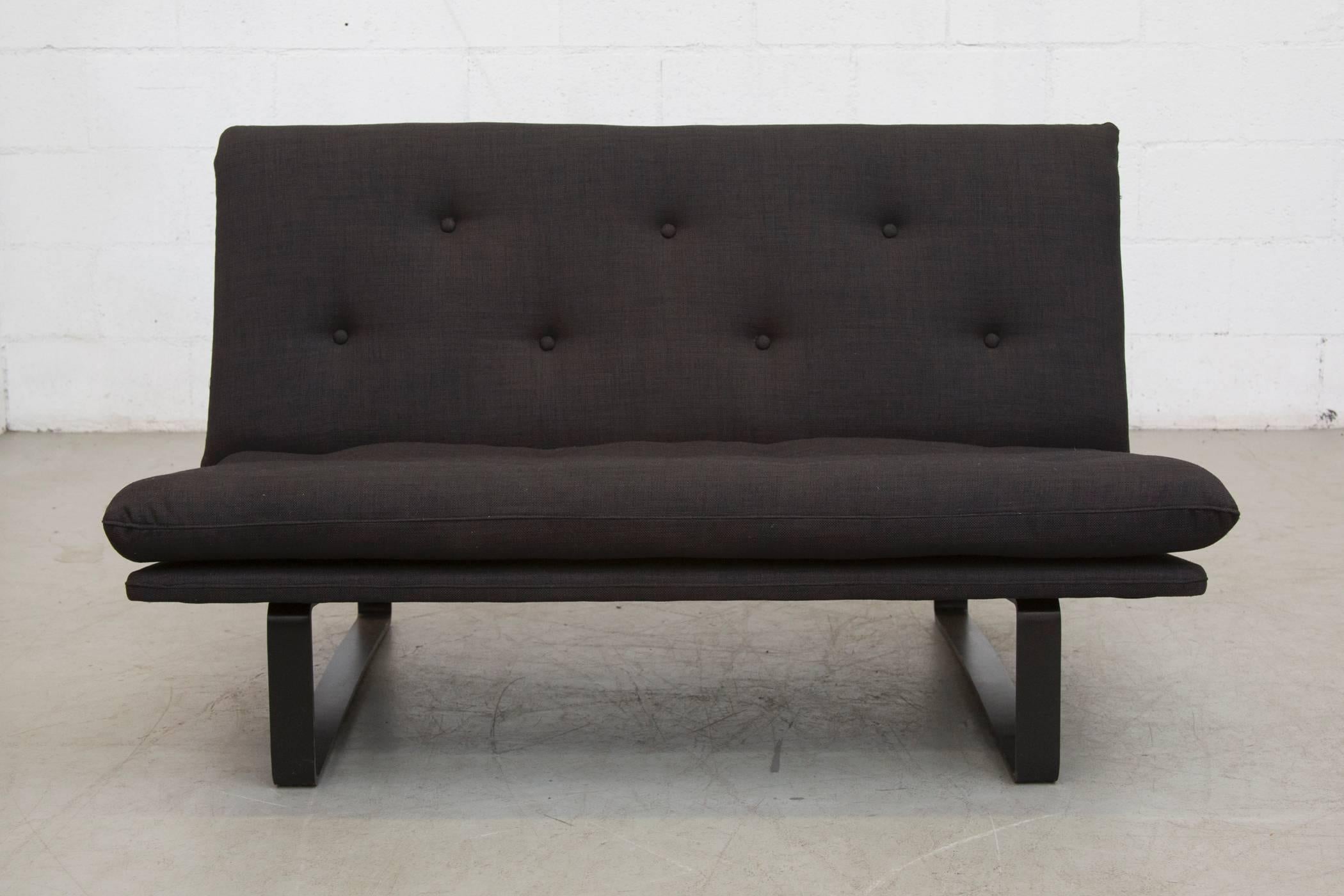 Sweet little loveseat newly upholstered in black with matching enameled black metal frame. In good original condition, some wear to the frame. Two available.