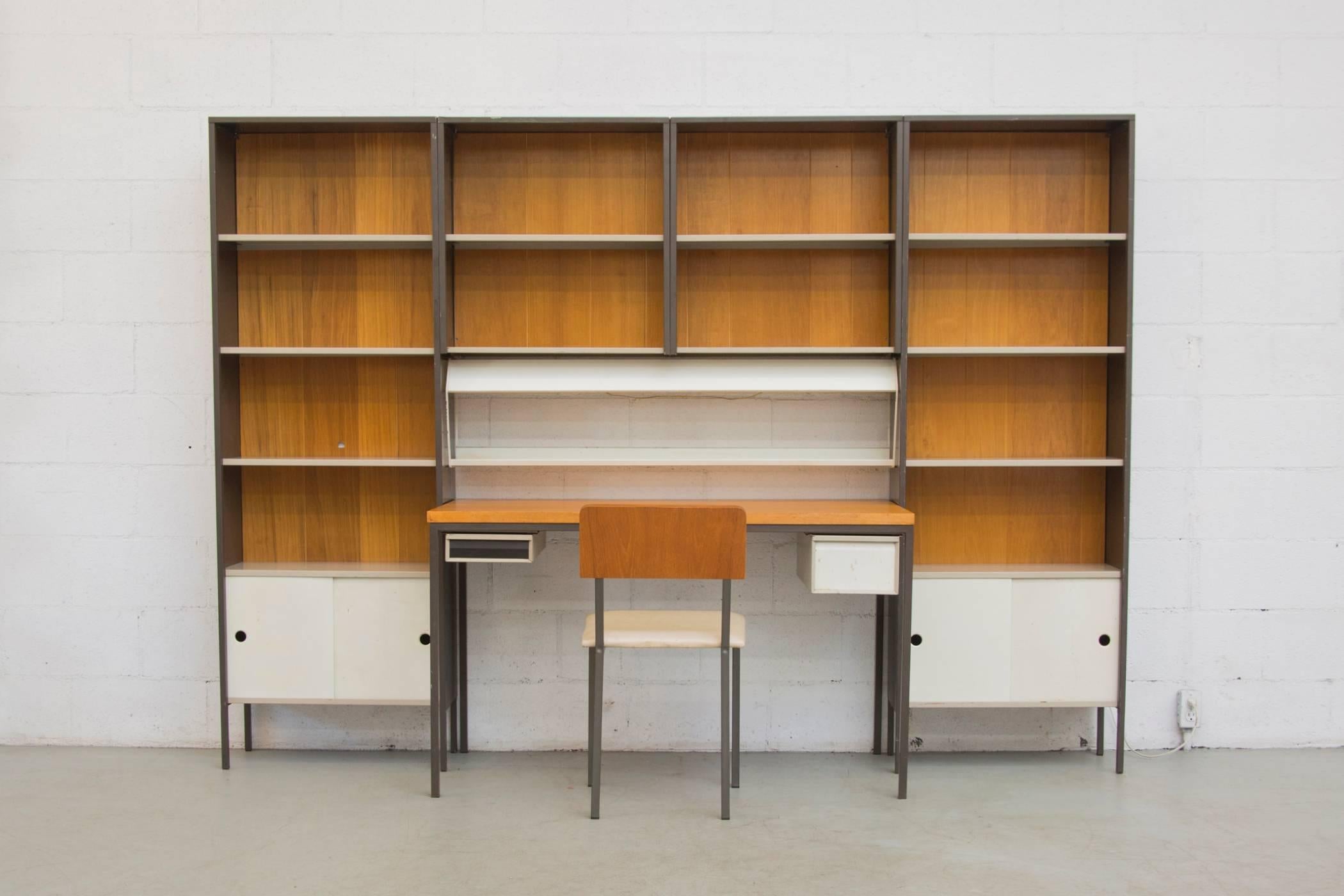 Rare & amazing Mid-Century Pilastro wall unit set by Coen de Vries in black and gray. A separate work desk sporting metal drawers and a coordinating teak top sits center to the wall unit. The overhead light slides in to the bottom of the overhanging