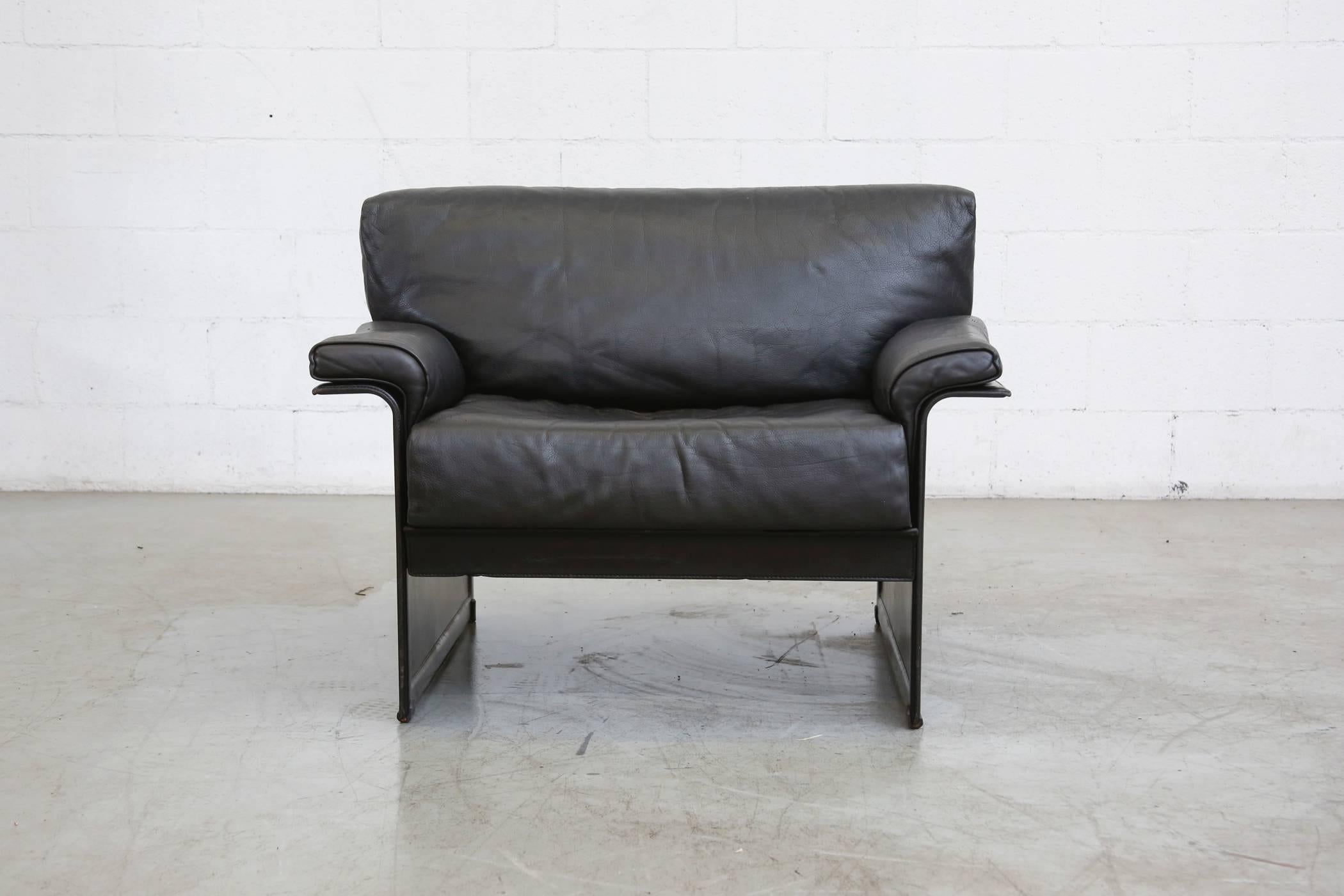 Cool stealth Italian black leather lounge chair by Tito Agnoli for MatteoGrassi. Original condition, visible signs of wear consistent with its age and usage.