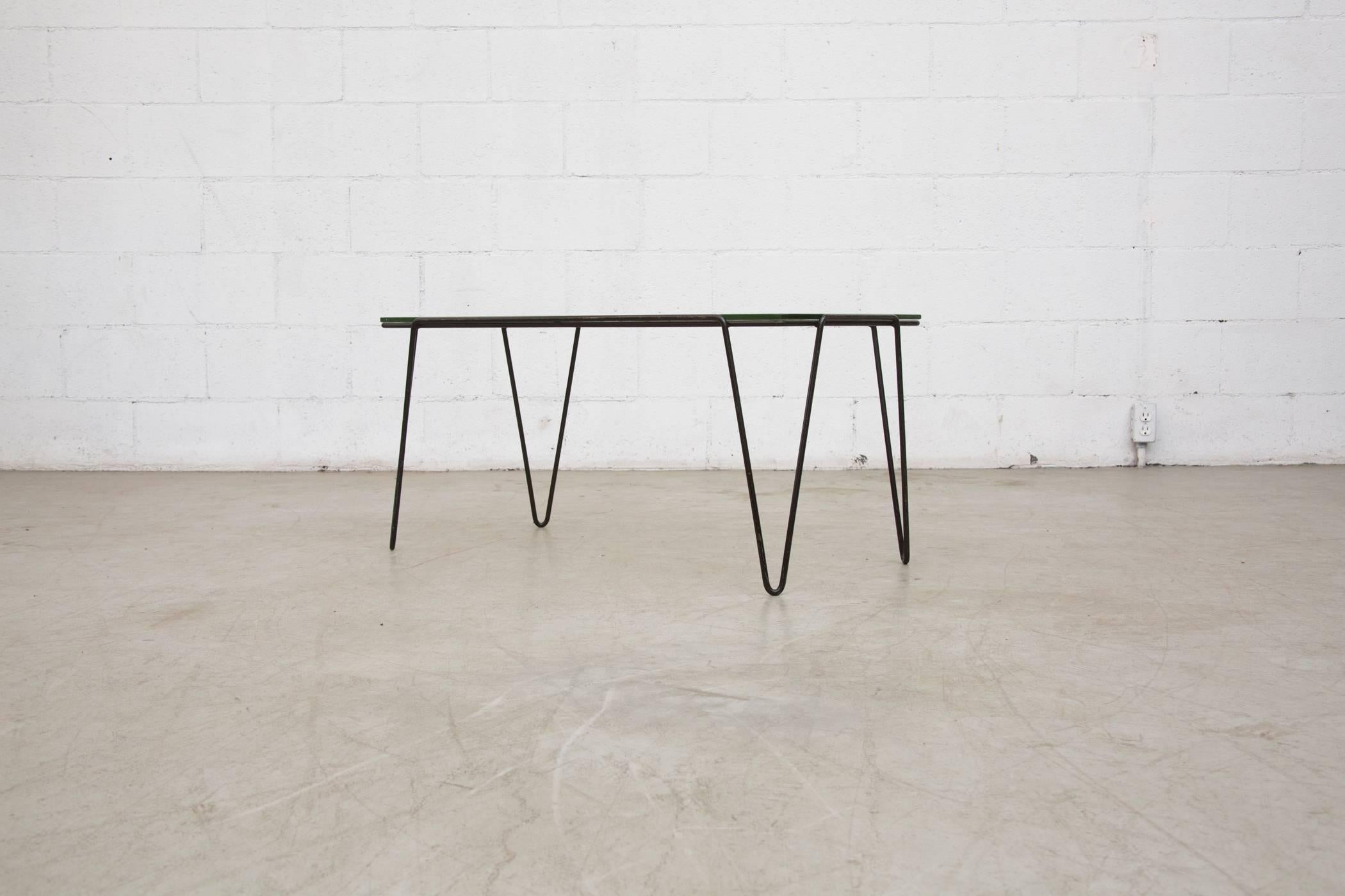 Rare rectangular glass table topped table with black enameled metal hairpin legs was designed for Goed Wonen, 1955. Rippled patio glass is in original condition with visible wear, as is the frame, consistent with its age and usage. Another one is
