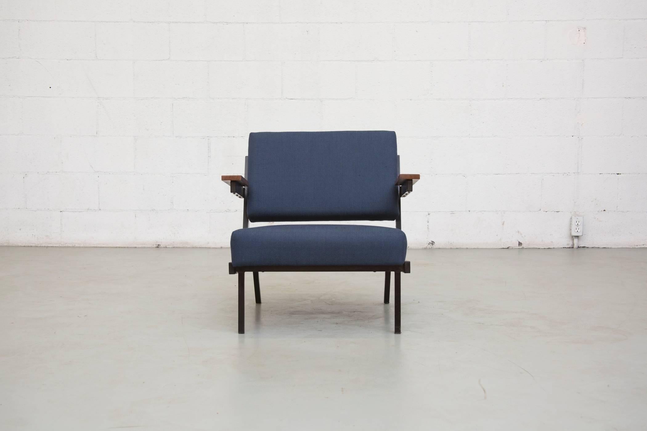 Great low sitting lounge chairs with enameled black metal frame and finished teak armrests. New in indigo upholstery. Frames are in original condition with visible signs of wear consistent with their age and usage. Set price.