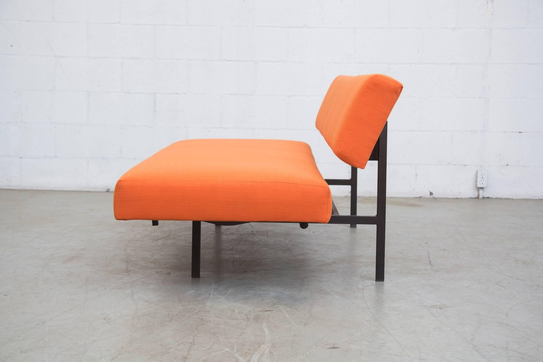 Original steel tubular framed sleeper sofa newly upholstered in orange. The seat pulls forward to transform the sofa into a single sleeping bed. Handsome and useful! Frame in original condition with some signs of wear consistent with its age and