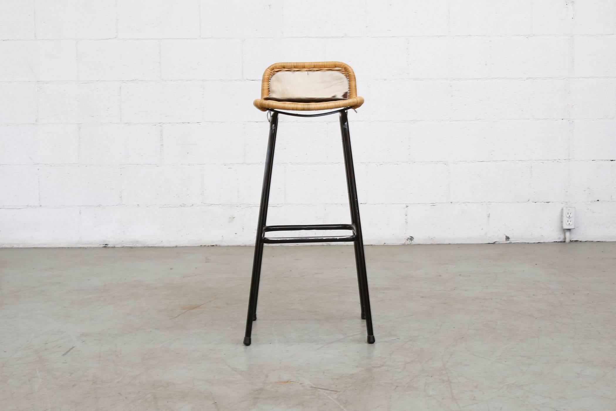 Tall bar stools with low back rounded wicker back with enameled black tubular frame and hand-cut cow inserts that have maintained the wicker perfectly. Signs of wear and enamel loss on the frame. Otherwise in good original condition. Set price.