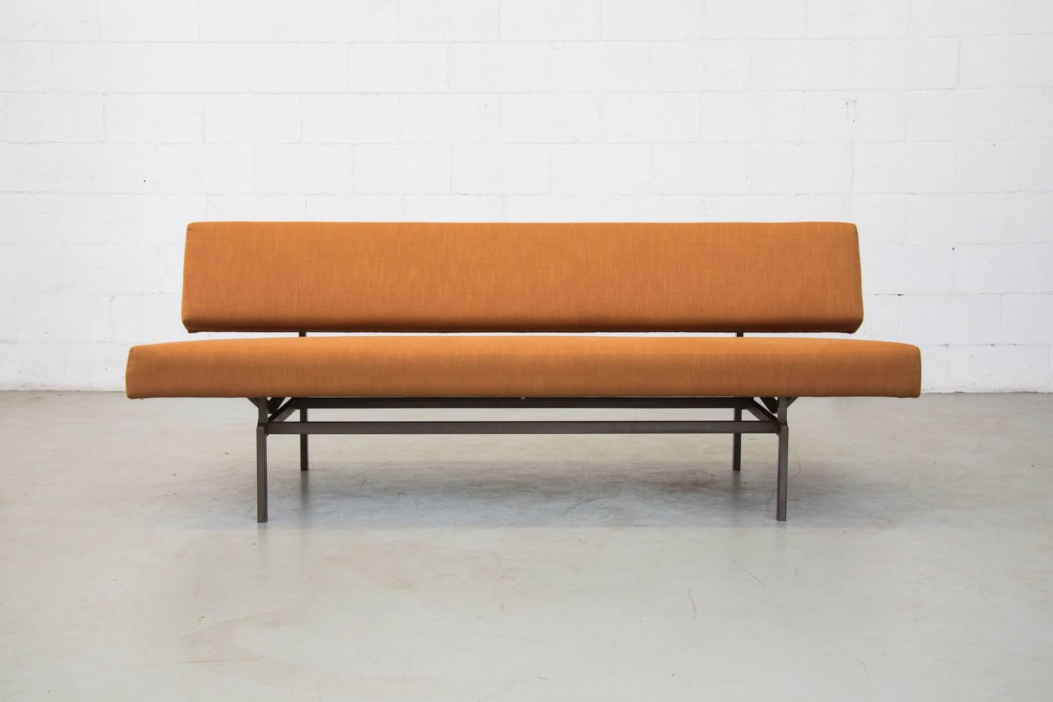 Newly upholstered in light rust colored fabric with original grey steel tubular framed sleeper sofa newly. The seat pulls forward to transform the sofa into a single sleeping bed. Frame in very original condition.