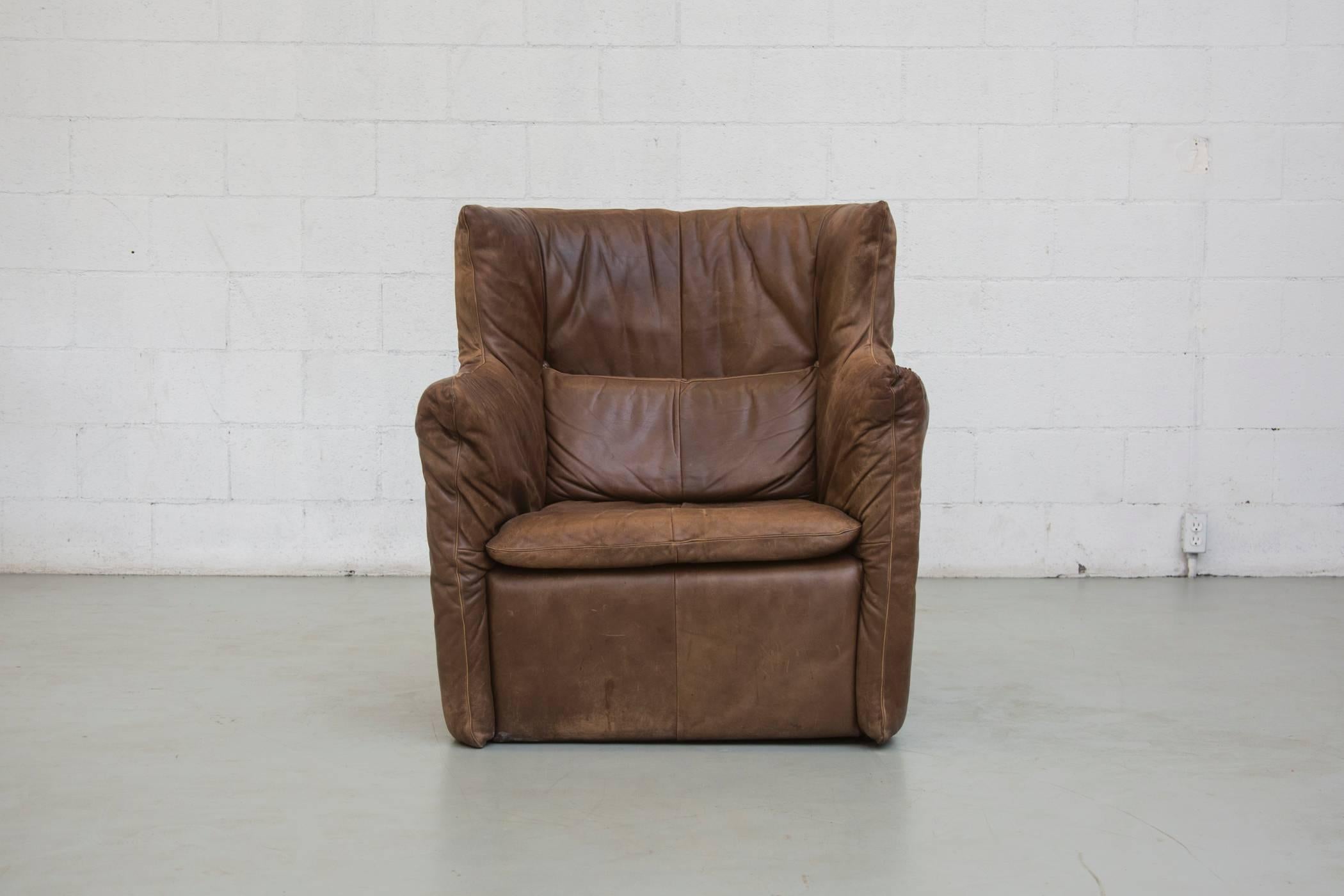Beautiful single leather lounge chair with beautiful dark brown natural patina. Includes matching back cushion. Minor scratching and markings typical of age and use.