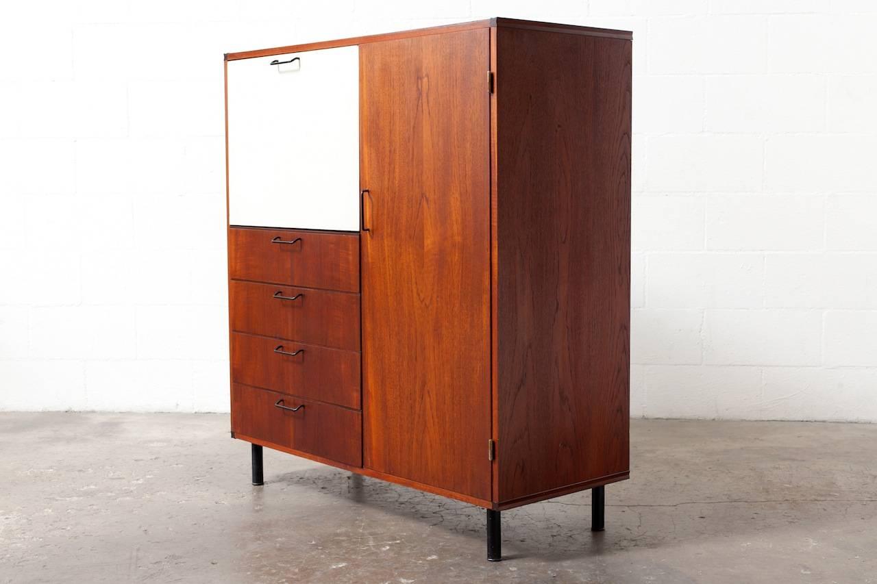Cees Braakman for Pastoe. Large finished teak cabinet with birch interior, signature curved inside drawers and black wire handle pulls. Stunning white formica accent on drop down bar front. Removable/adjustable shelving and drawer space. Nice