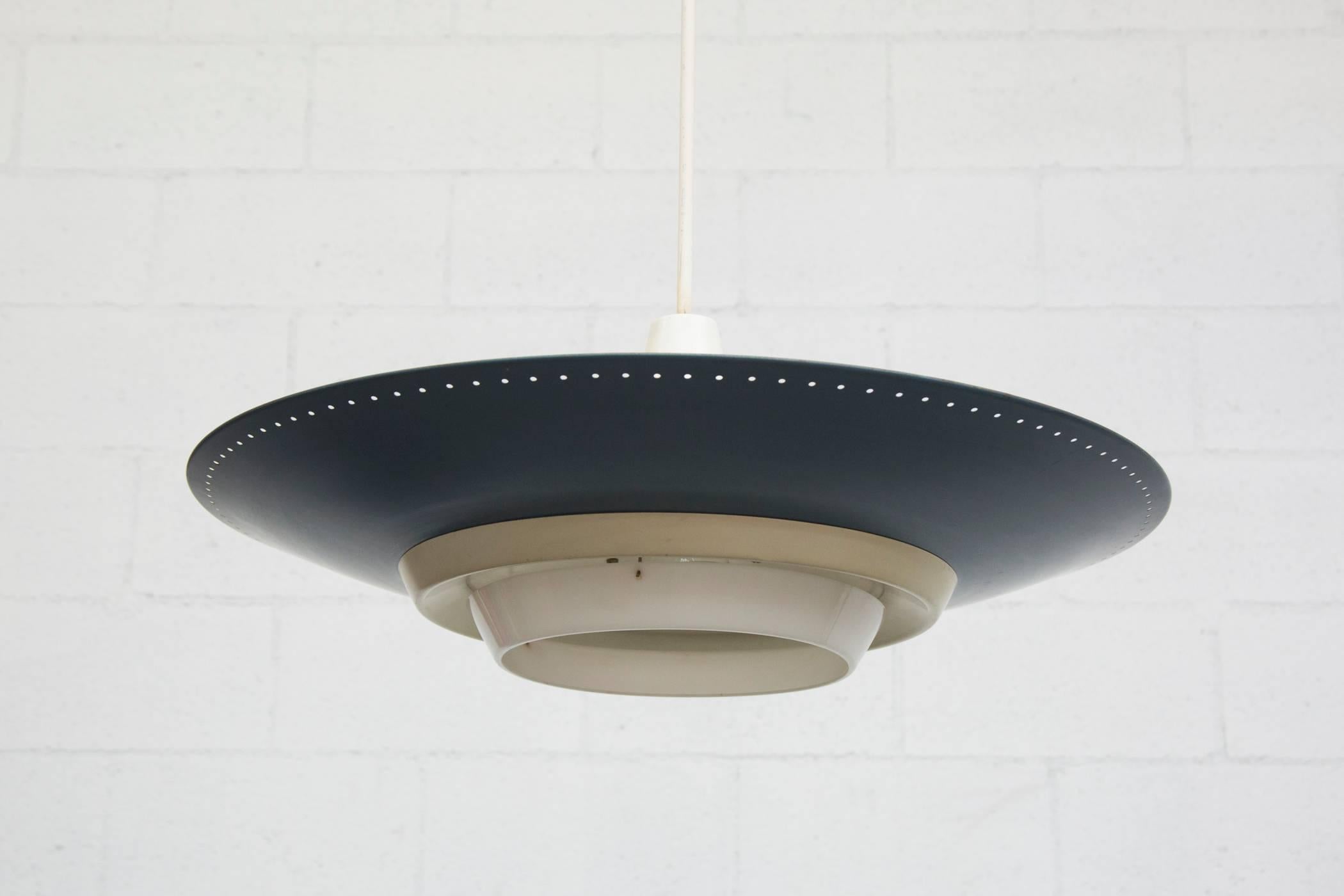 Original 1950s Industrial enameled metal rondelle ceiling pendant. Deep blue enameled spun aluminum shade with perforated edge, and bone white accents. Triple light sockets for uplighting and a single spot for below, 1950-1960. Very original