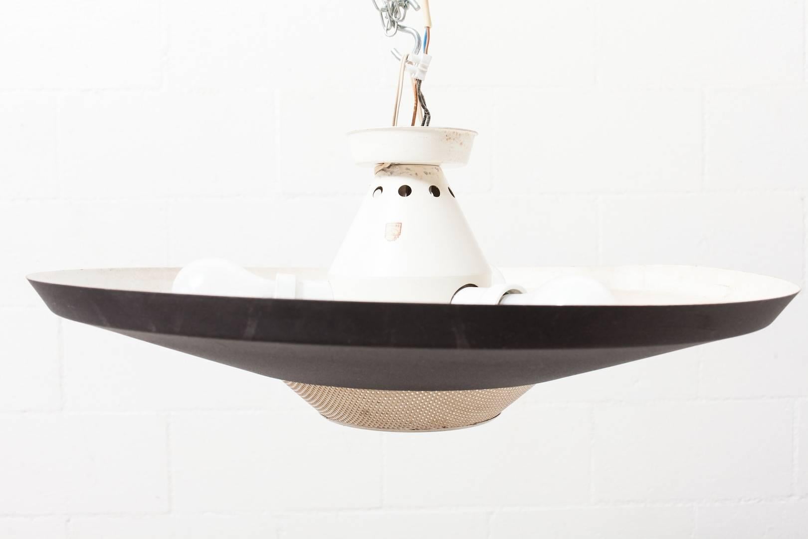 Beautiful Industrial flush mount ceiling lamp from the Dutch brand Philips. Designed by Louis Kalff, circa 1960. Matte black inverted shade with bone white enameled metal perforated detail to house a downward spot light while three light bulbs are