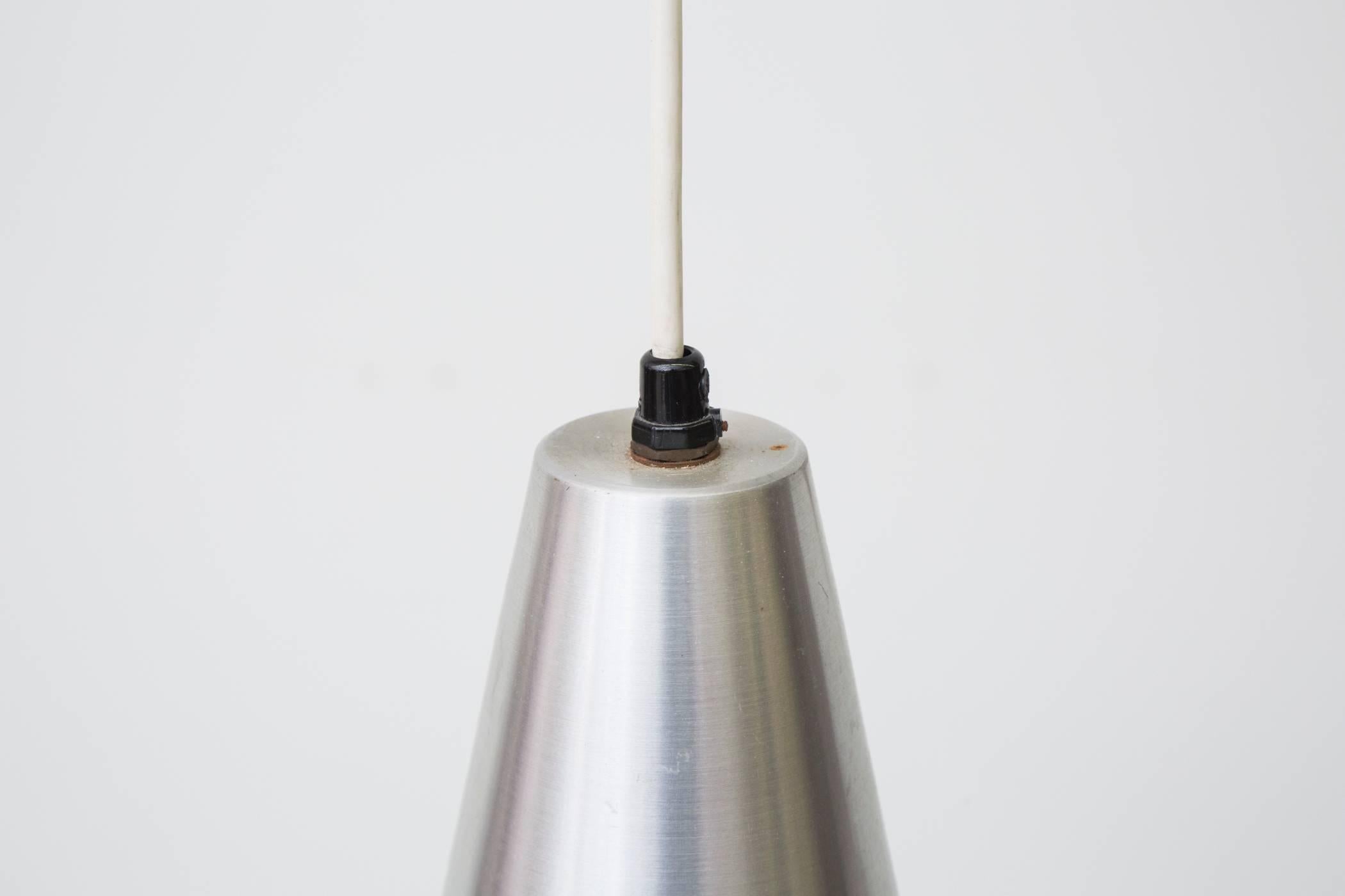 Large spun aluminum cone pendant with black band. Emits beautiful diffused light. Original condition with some signs of wear consistent with its age and usage.