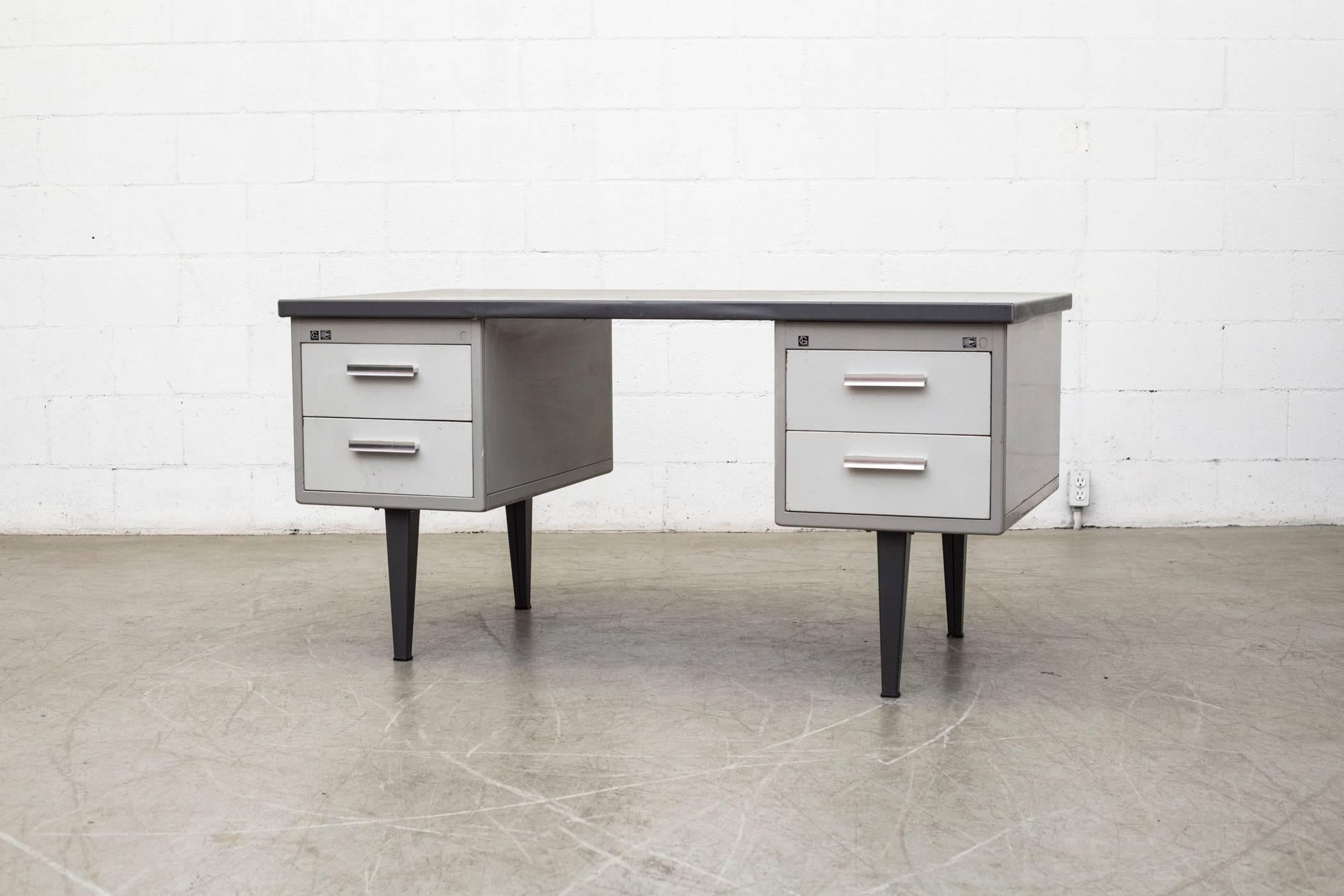 Industrial Mid-Century Grey Enameled Metal Gispen Desk with Bone White Drawers and Black Enameled Metal Feet and Linoleum Wrapped Top in Good Original Condition with Visible Wear Consistent with its age and usage. No Keys included.