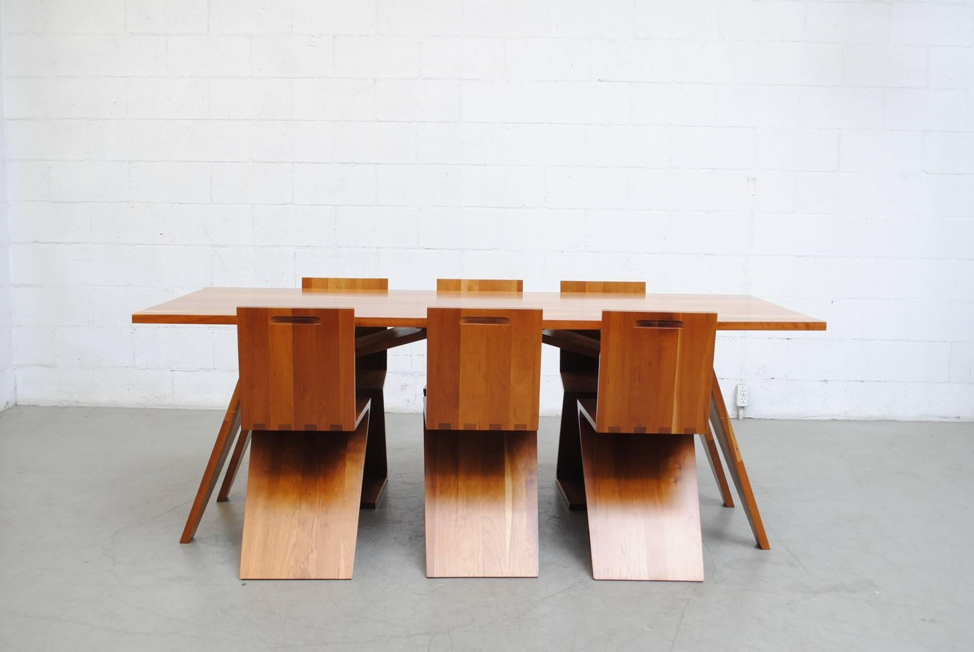 A fine display of Dutch Design and craftsmanship in this gorgeous solid cheerywood dining set as designed by Gerrit Rietveld and handmade in the early 1980s consists of a large table with six matching 'Z' shaped chairs. This set was custom ordered