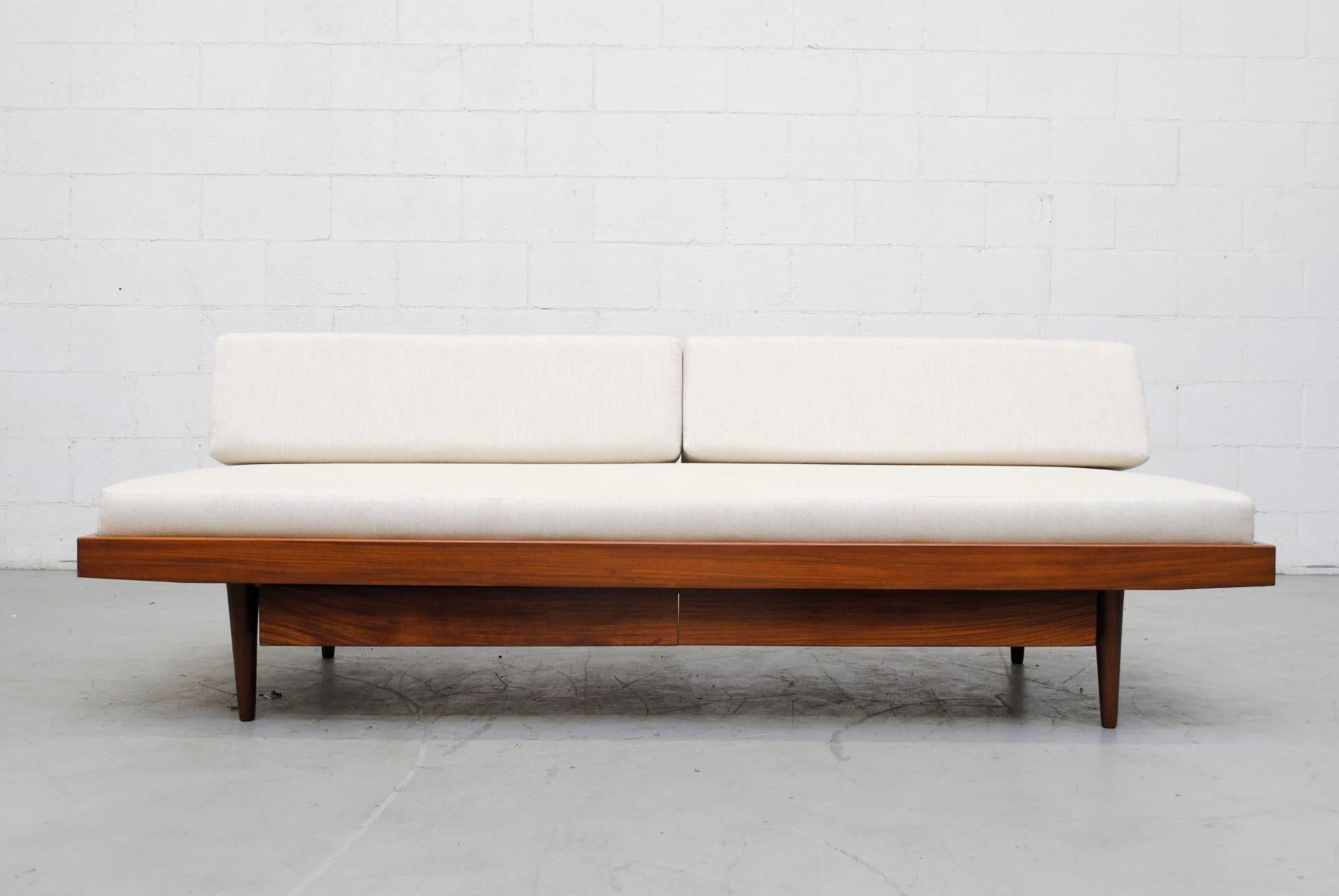Lightly refinished midcentury teak daybed with lower double storage drawers and new bone white upholstered mattress and bolsters. Good original condition.