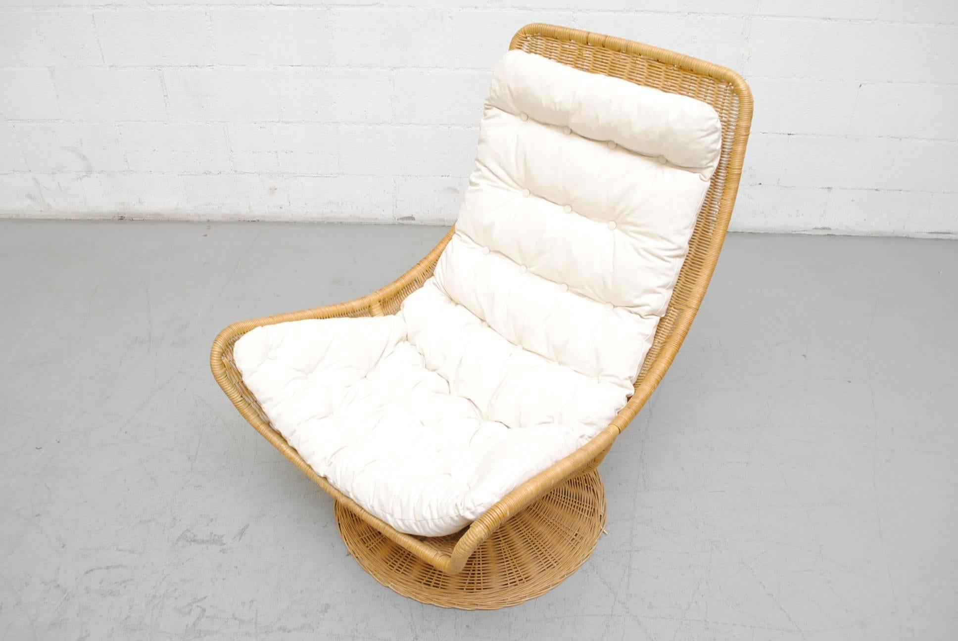 Gorgeous woven rattan swivel chair with new natural canvas cushion. Frame in good original condition with some signs of wear consistent with its age and usage.