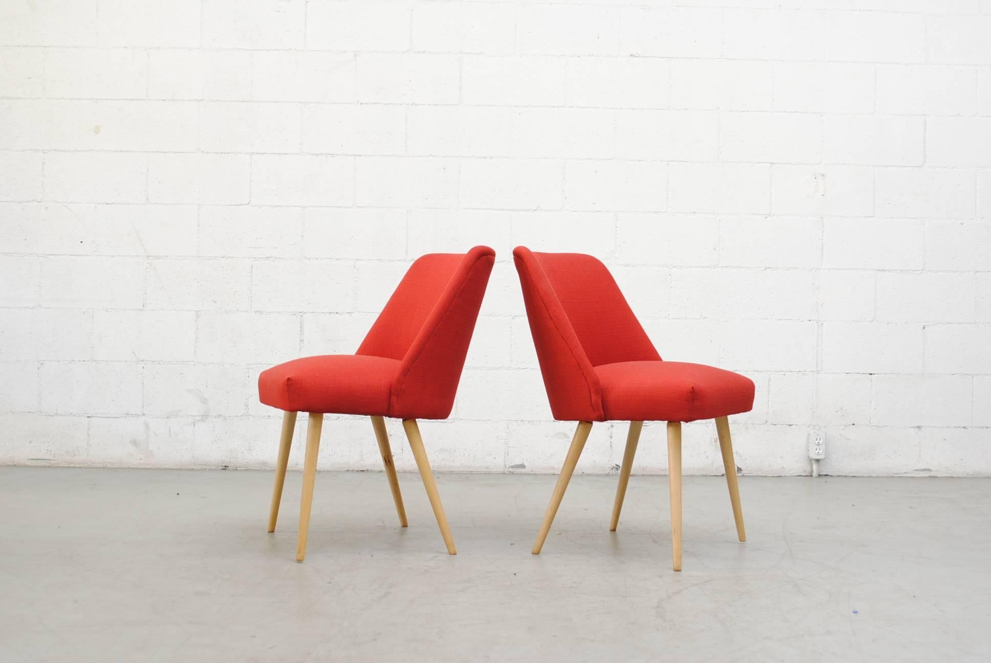 Mid-Century Modern dining or cocktail chairs. Newly upholstered in lipstick red. Lightly refinished natural birch tapered legs. Otherwise in original condition.