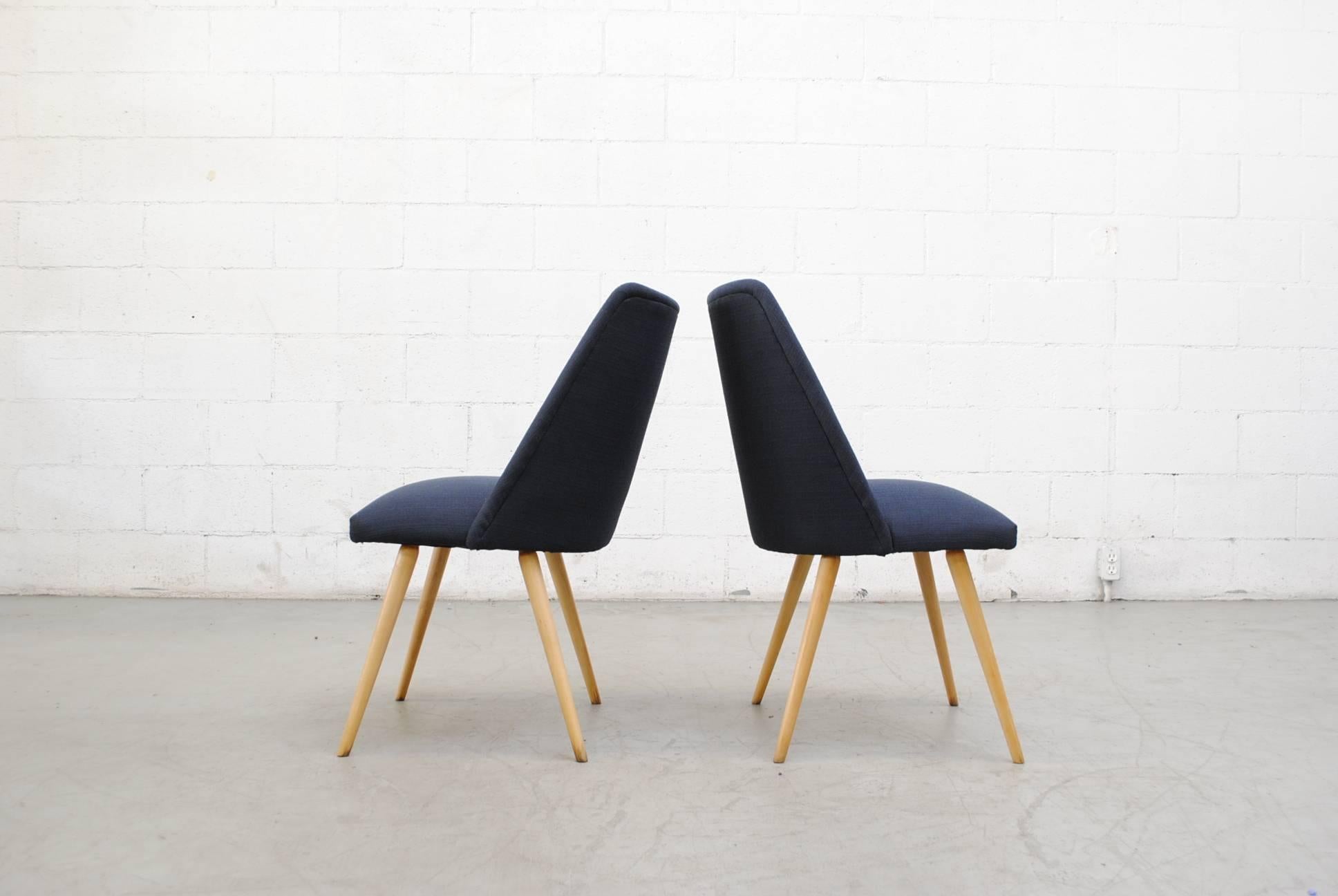 Mid-Century Modern dining or cocktail chairs. Newly upholstered in navy. Lightly refinished natural birch tapered legs, otherwise in original condition.