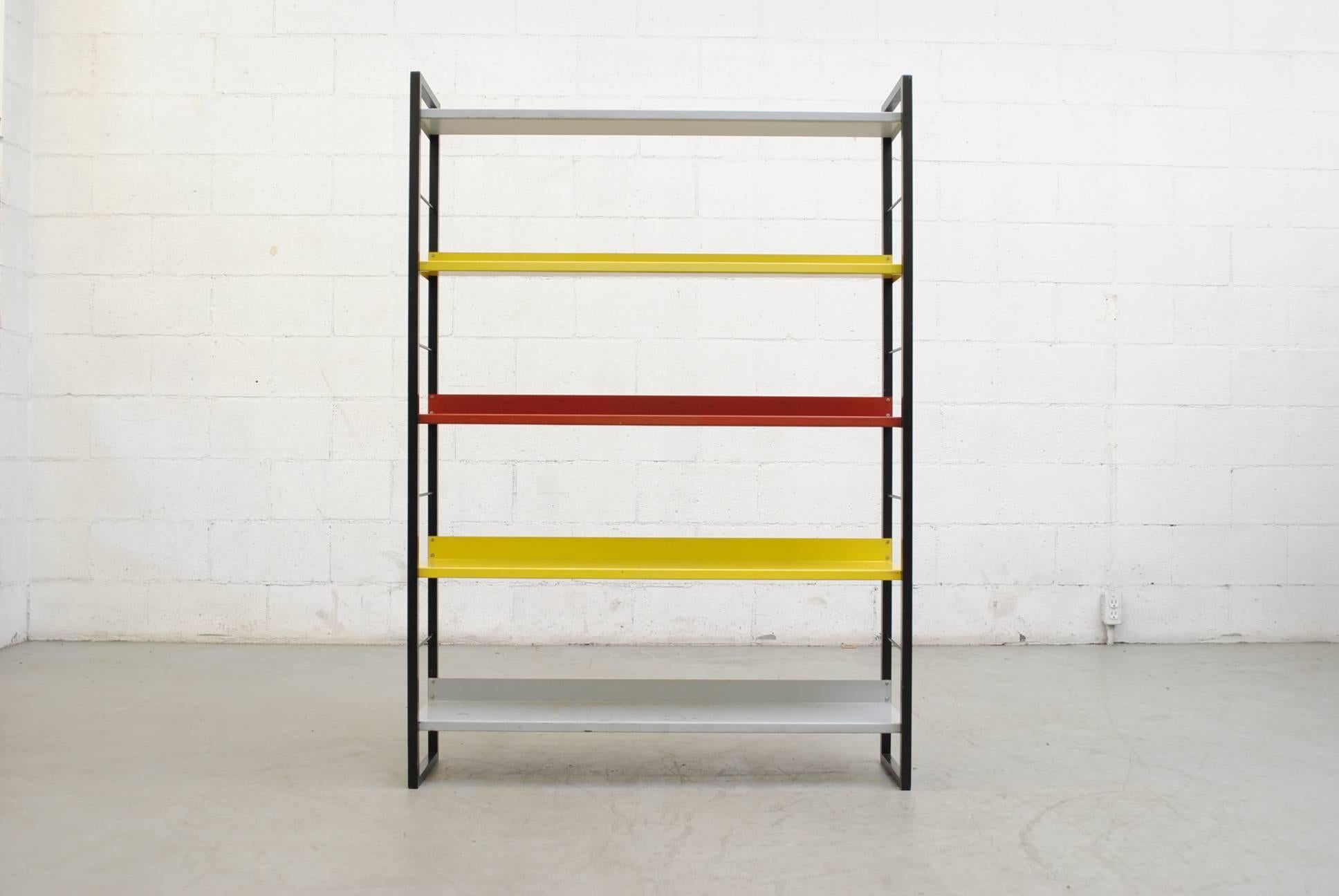 Bauhaus inspired Industrial multicolored enameled metal shelving unit with black steel frame and five multicolored shelves. Visible wear and use, some paint loss, in original condition.