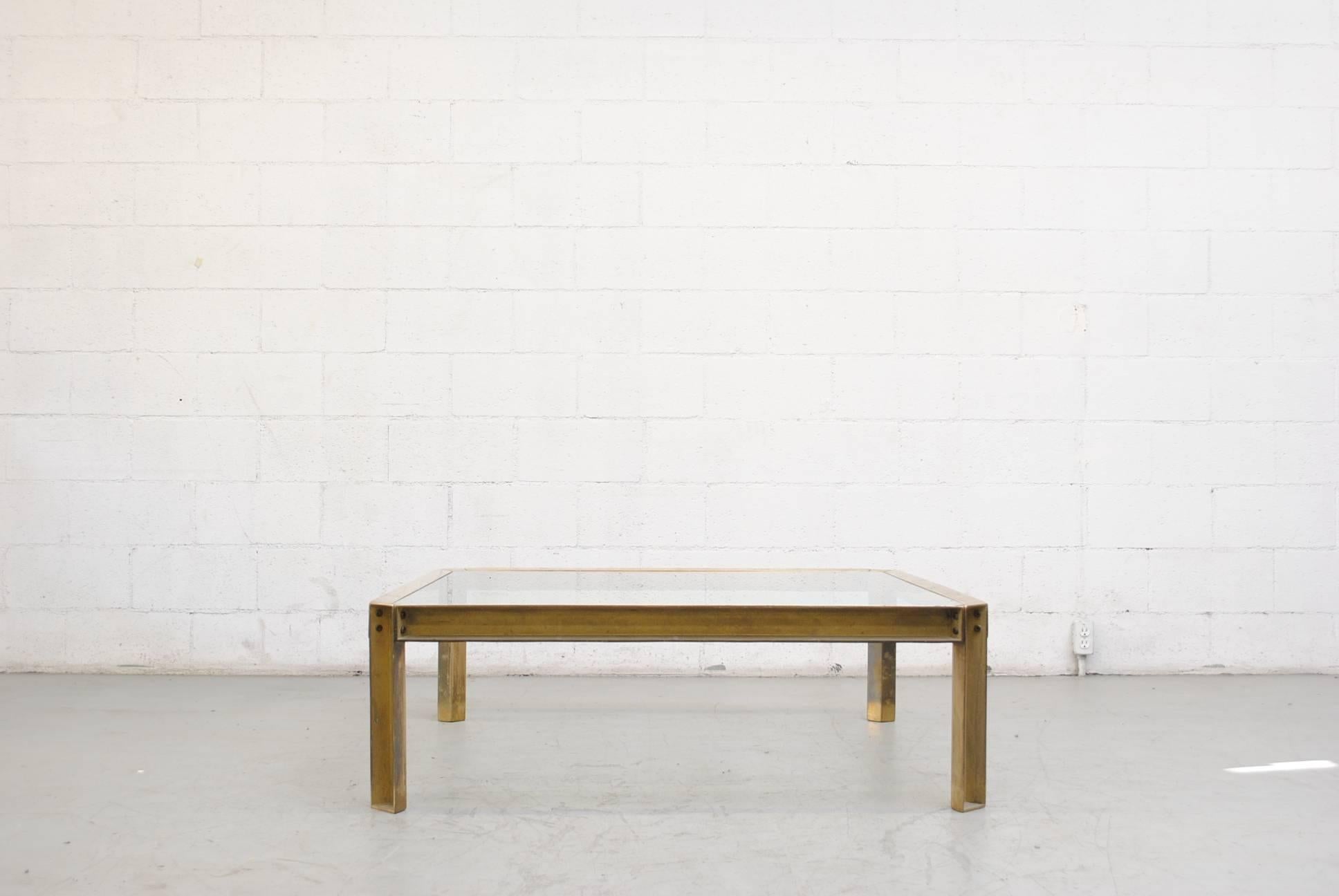 Industrial brass and glass coffee table with a raw construction look. Original condition with visible patina to the brass and visible wear to the frame and inset top. Peter Ghyczy studied architecture with an industrial design background at the