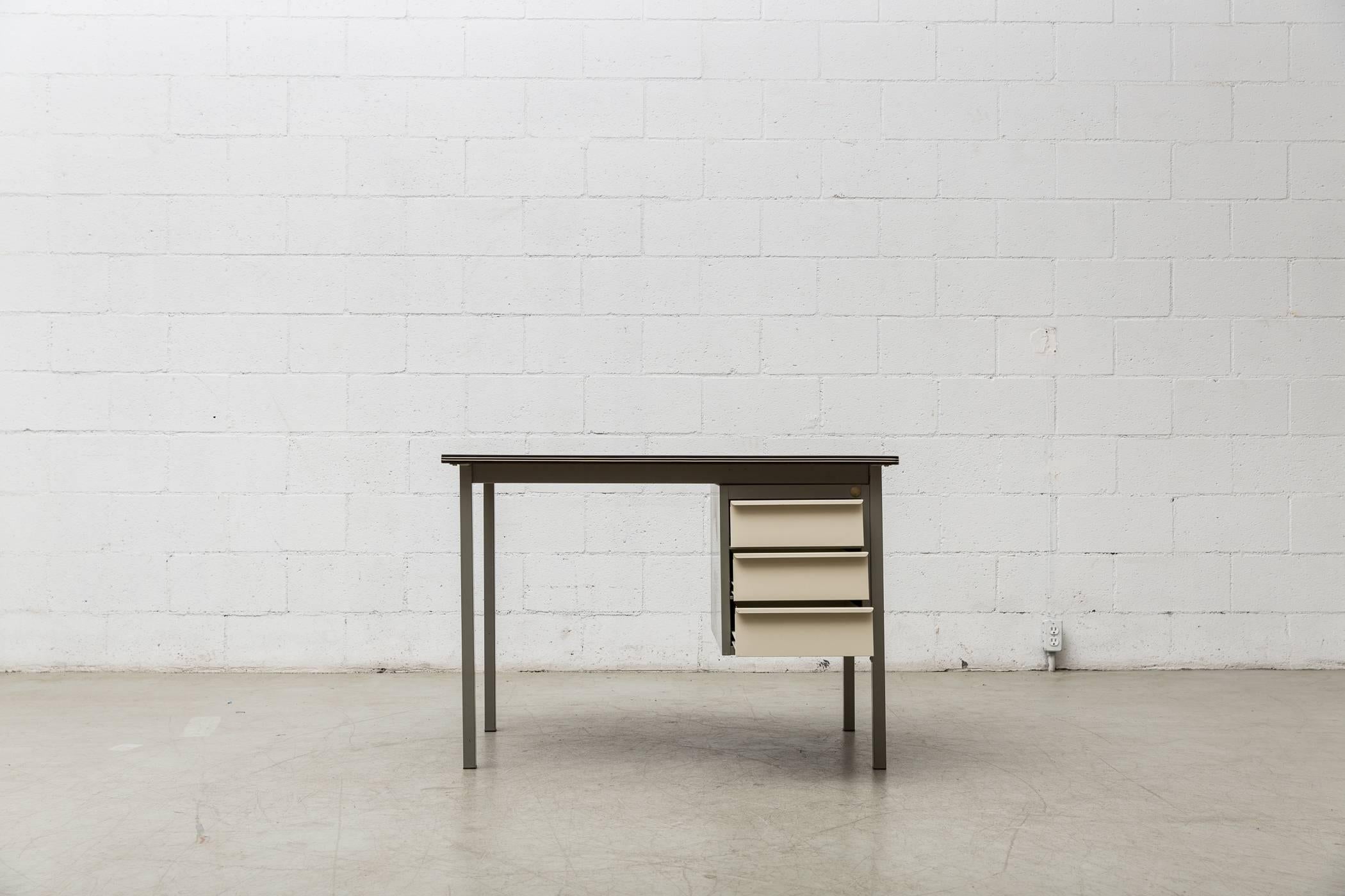 Super Dutch Industrial desk with grey enameled metal frame and white enameled cantilevered drawers and almost black linoleum top. In original condition with visible wear, some visible enamel loss and scratching to surfaces. Wear is consistent with