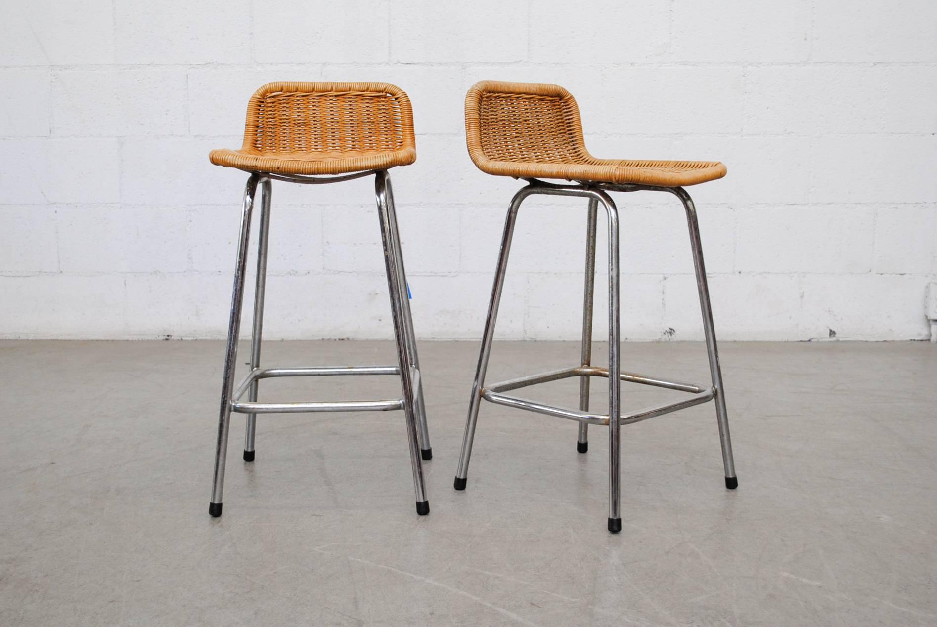 Pair of Charlotte Perriand style counter stools with wicker seating and chrome frame. Good original condition with nice patina to wicker, chrome is visibly worn, consistent with its age and usage. Set price.