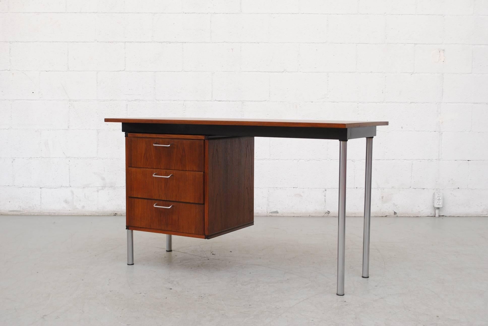 Lightly refinished midcentury teak writing desk by Cees Braakman from the made-to-measure series with three sliding drawers. Brushed chrome and pulls and legs. Good original condition.