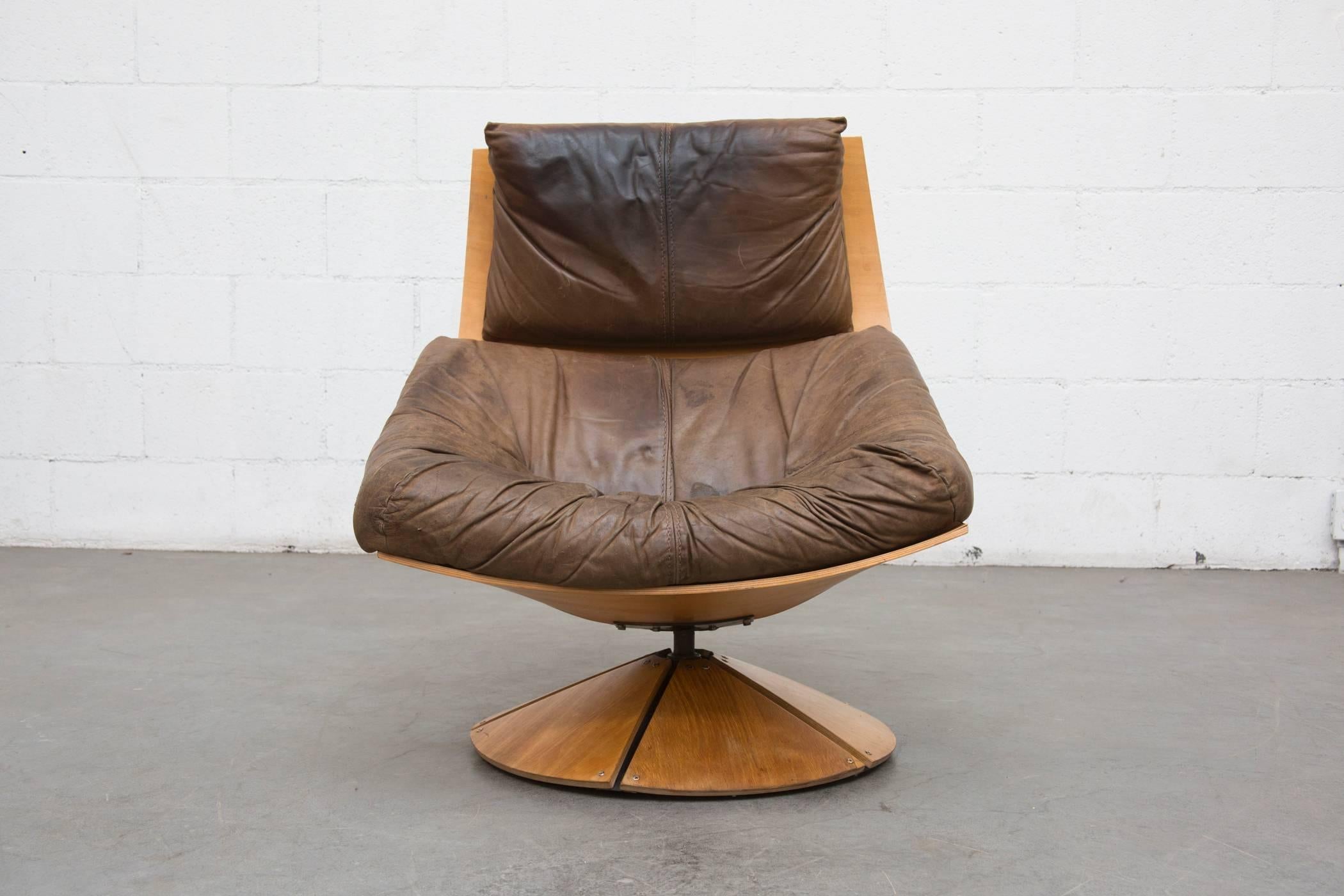 Rare Gerard Van Den Berg swivel lounger for Montis with birch plywood frame and well loved brown leather seating with beautiful patina. In original condition with visible signs of wear to leather and some signs of wear to frame both consistent with