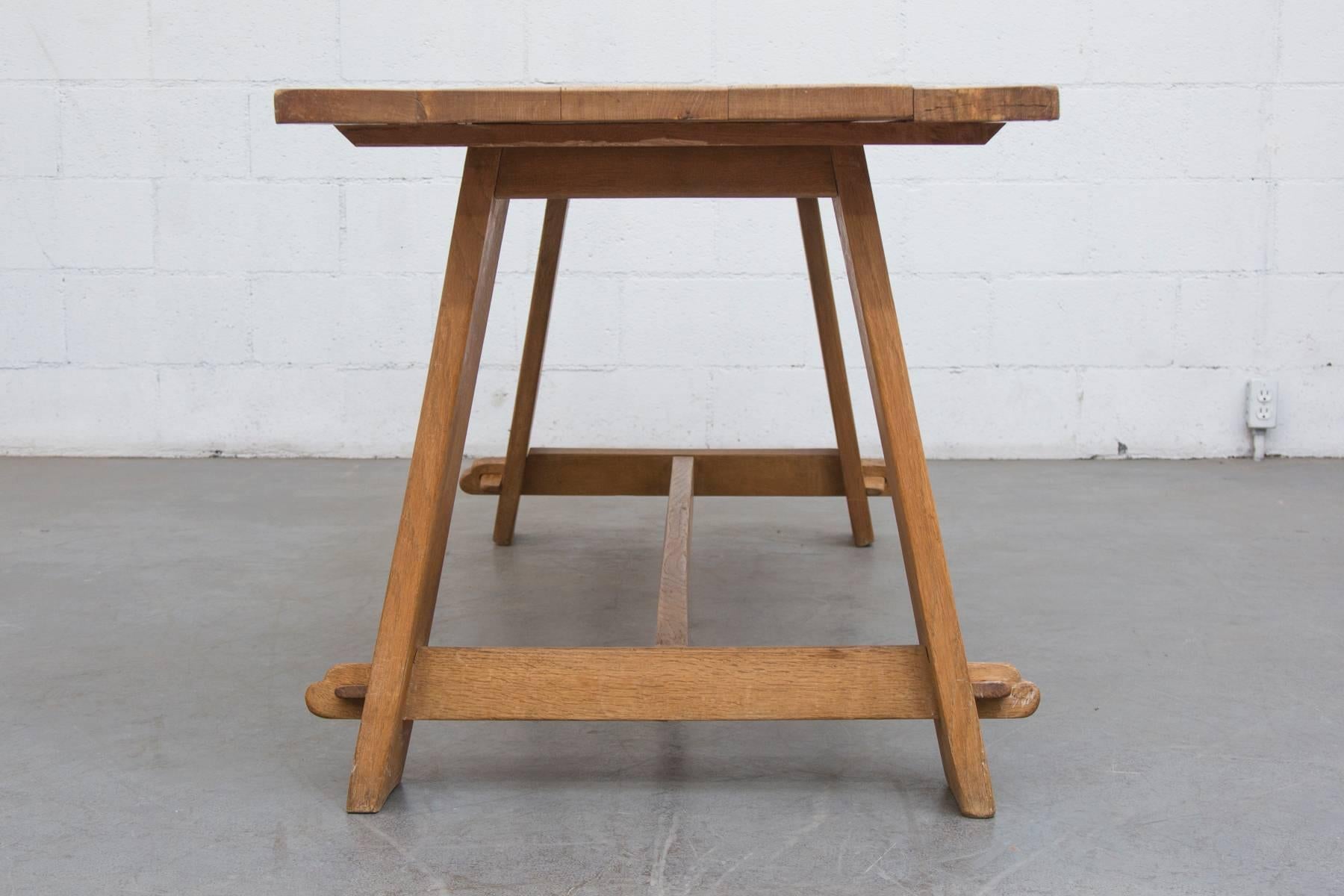 Amazingly simple solid oak trestle dining table constructed with tension pegs.
In original condition with visible wear consistent with its age and usage.