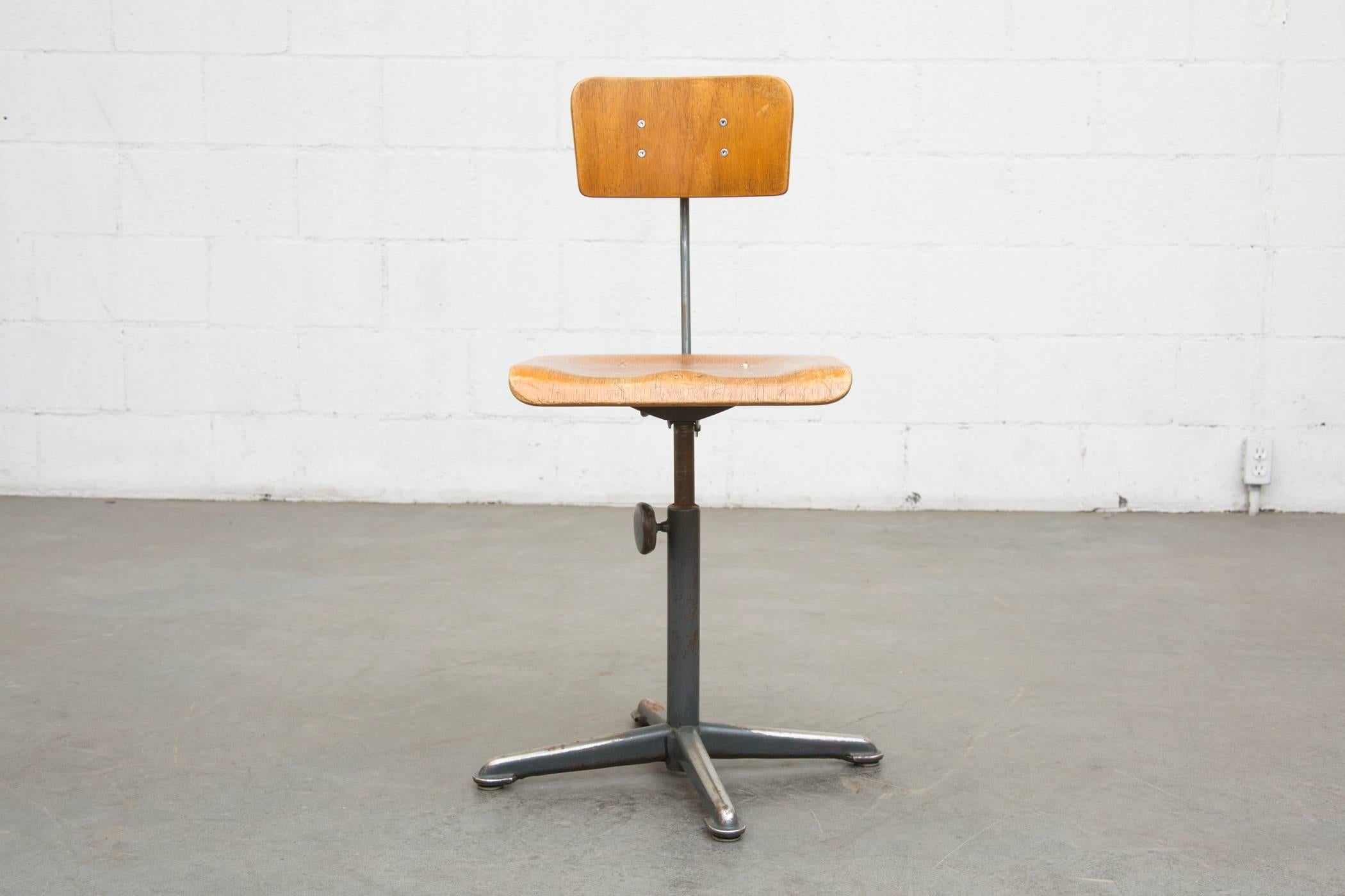 Early edition plywood seat and back adjustable height drafting stools. All in very original condition with visible signs of wear and enamel loss. Many have small gouges at the back/center of the seat where the metal back support adjusts forward.
