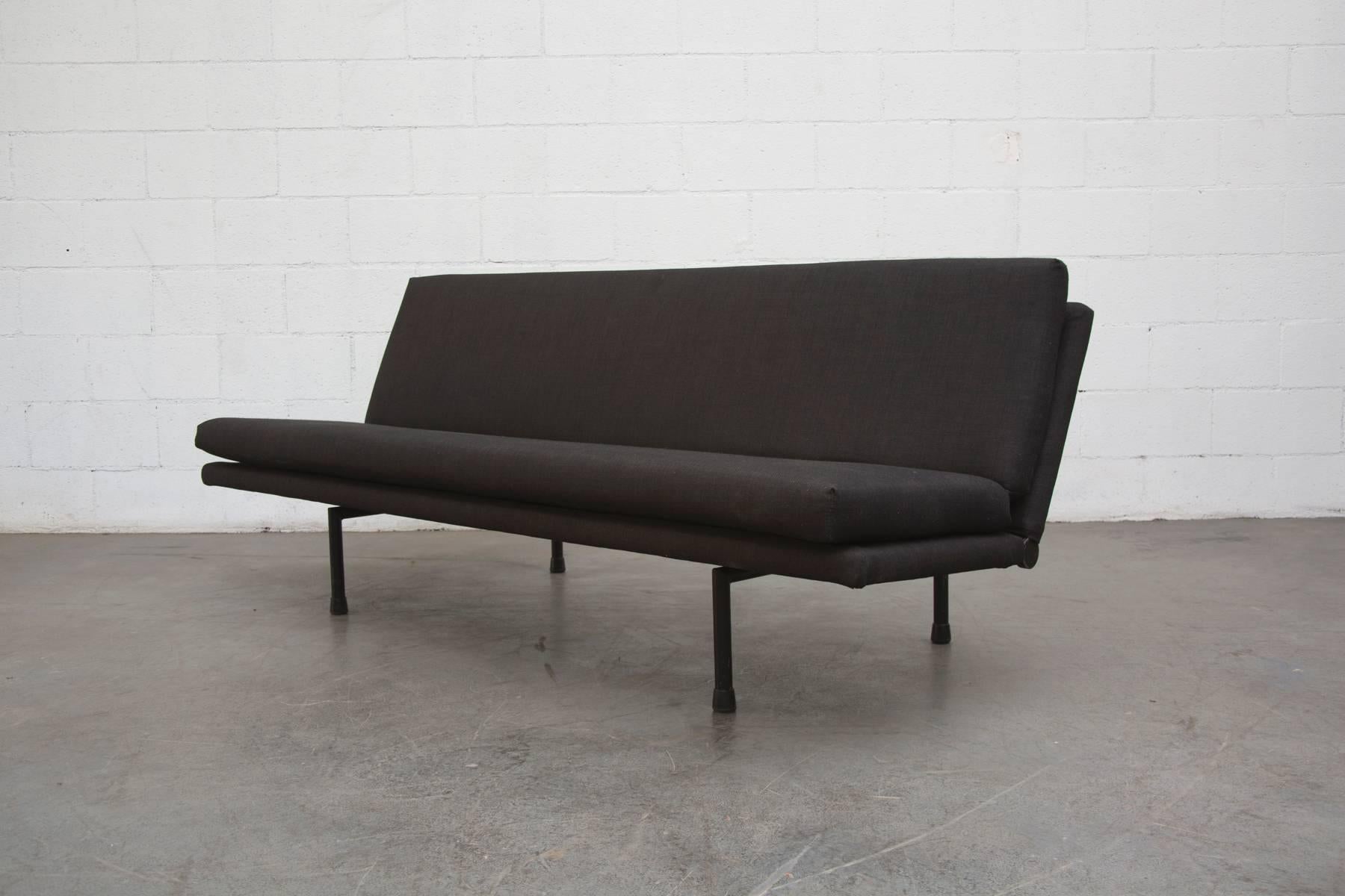 Amazing convertible sofa completely re-upholstered in black. Very French Industrial moderne. Frame is in original condition with visible signs of wear. Some enamel loss consistent with its age and usage. See matching lounge chairs that also convert