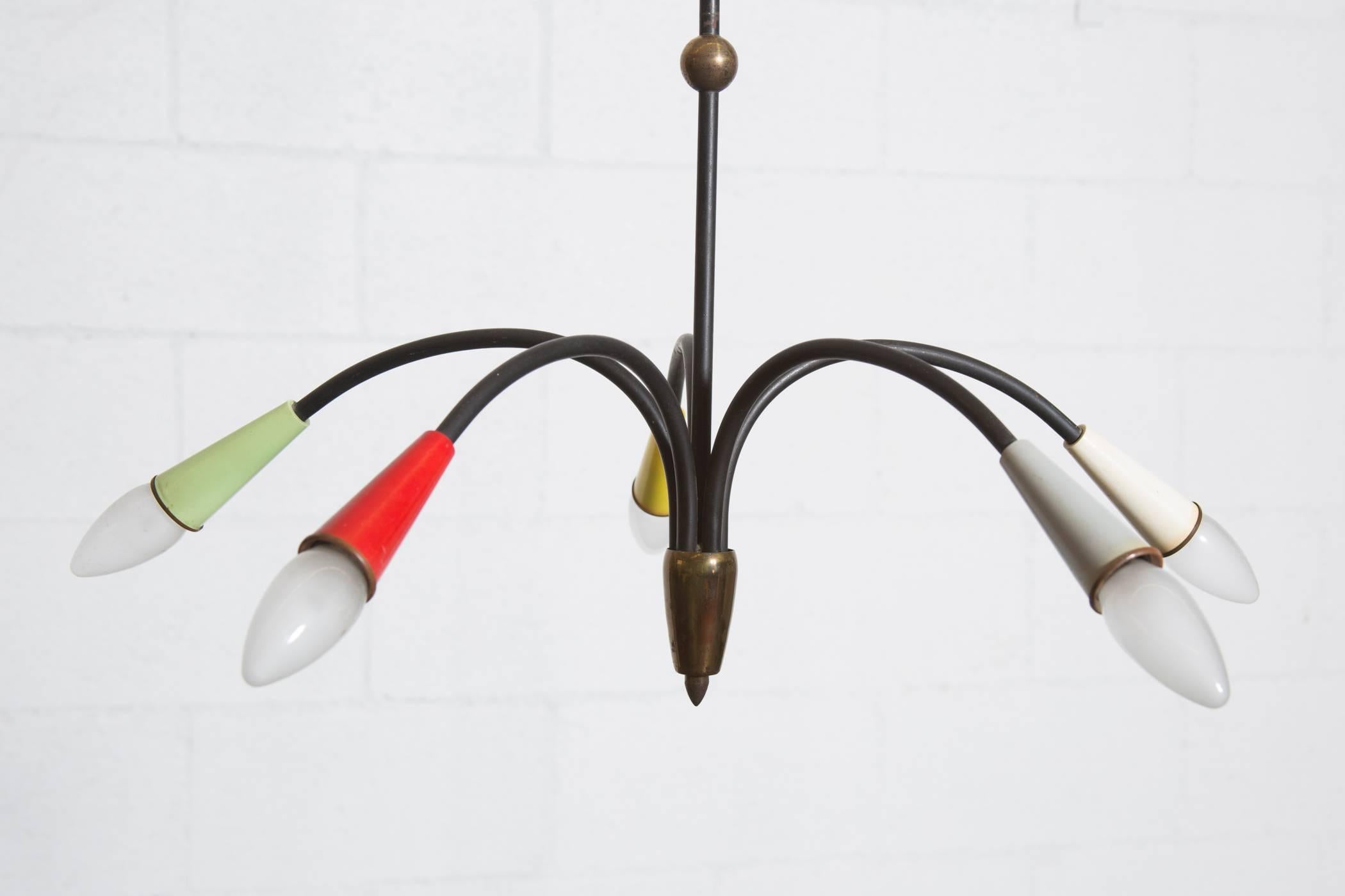 Sweet and delicate, Mid-Century, five armed black enameled metal chandelier with brass accents and multi-colored socket casings. Original condition with some wear consistent with its age. Shown with original European candelabra bulbs. Will provide