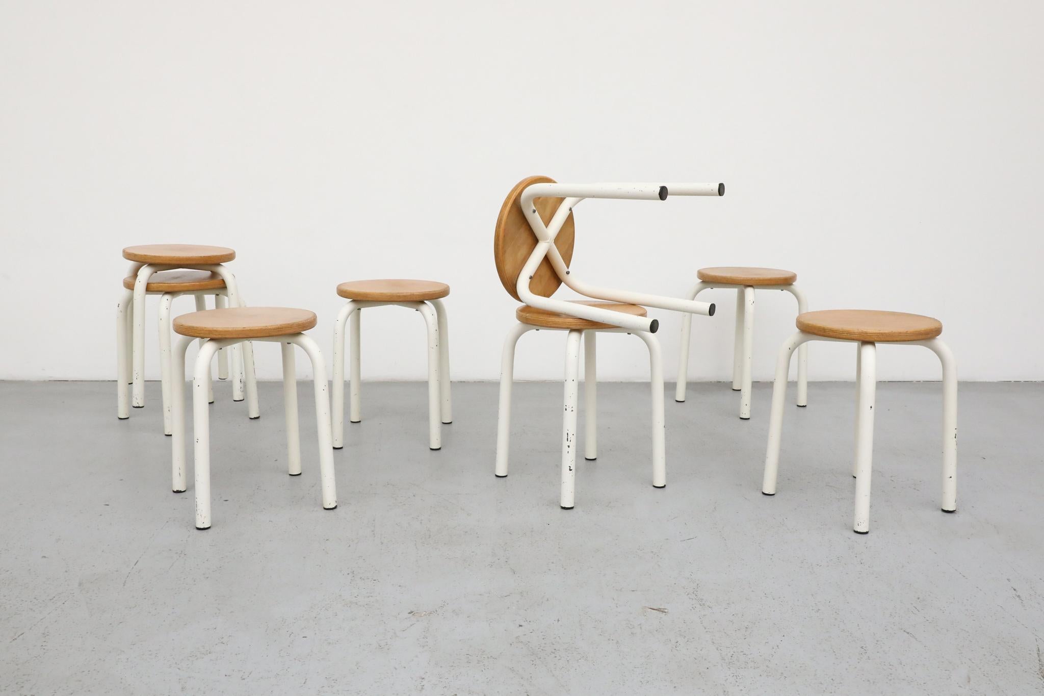 Vintage industrial task stool produced by Belgian manufacturer Tubax, designed in the style of Fritz Hansen. Featuring a sturdy white enameled tubular steel frame and a thick circular wood seat, this utilitarian design reflects the functional