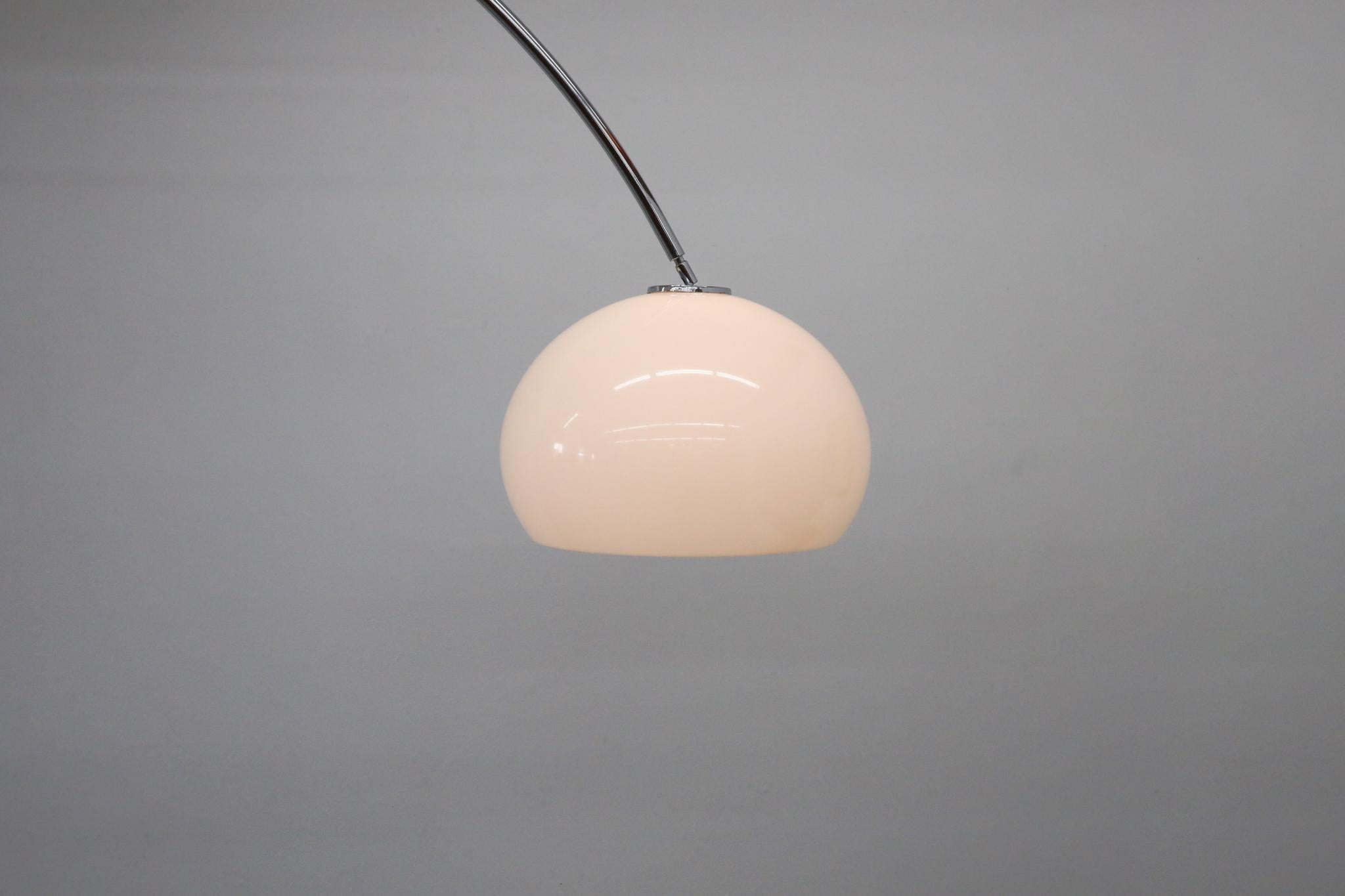 Exemple frappant de l'ingéniosité du milieu du siècle dernier, cette lampe à arc allant du sol au plafond est dotée d'un élégant mât de tension chromé associé à un abat-jour surdimensionné en dôme de plexiglas blanc. Suspendu à un bras chromé