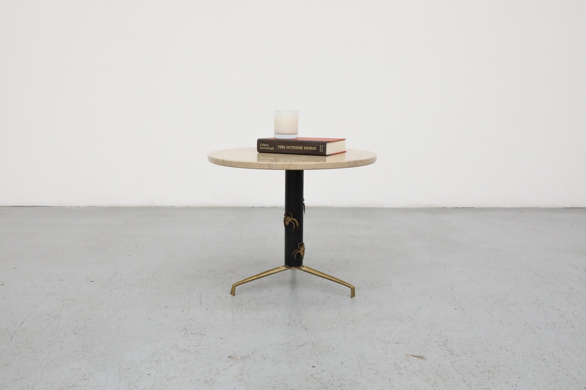 Striking Italian Mid-Century Modern side or lounge table. Likely produced in the early 1960s this attractive table has a round marble top and black enameled metal base with brass spider motif on matching brass feet. 
The round top is detached. The