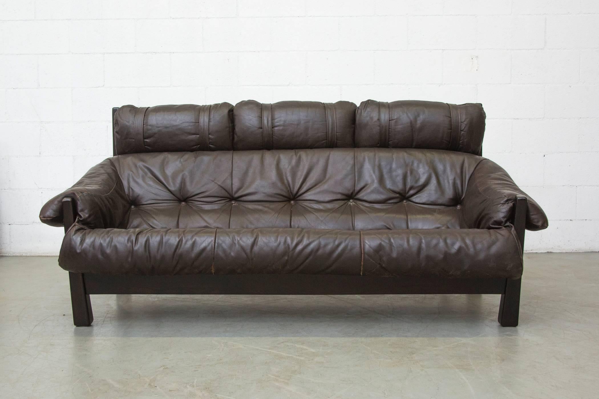 Gerard Van Den Berg leather sofa in dark chocolate colored leather with great patina and heavy wood frame. Smart tension strap support system. Single matching lounge chair and ottoman available. Listed separately.