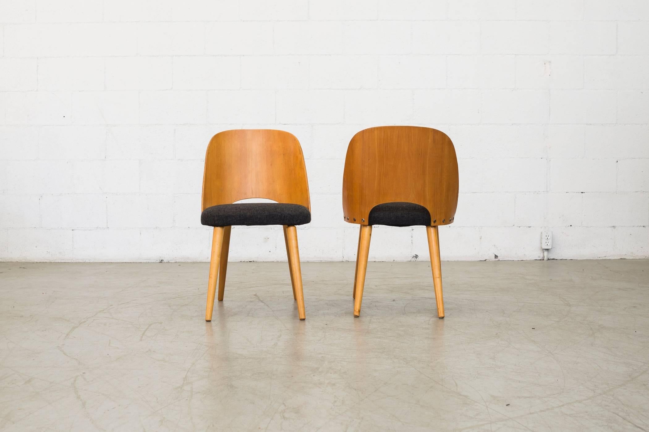 Designed by Oswald Haerdtl, architect and designer and a pupil of Kolo Moser and later an assistant of Josef Hoffmann. Made of bent beech plywood, curved back with newly charcoal upholstered seats and tapered legs. Normal traces of wear for its age