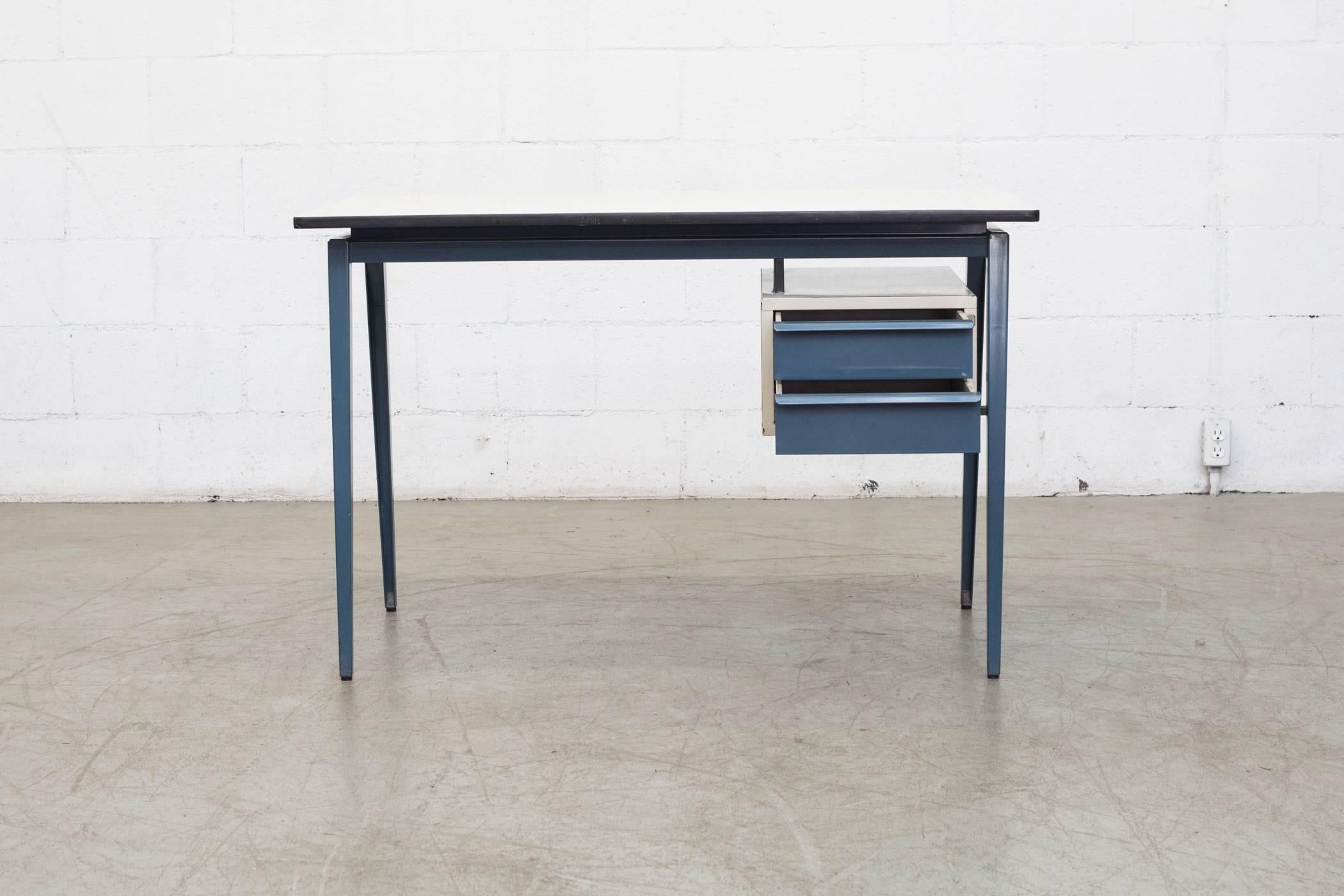 Dutch blue enameled metal drawers and legs with grey cabinet and formica top in original condition with visible signs of wear consistent with its age and usage.