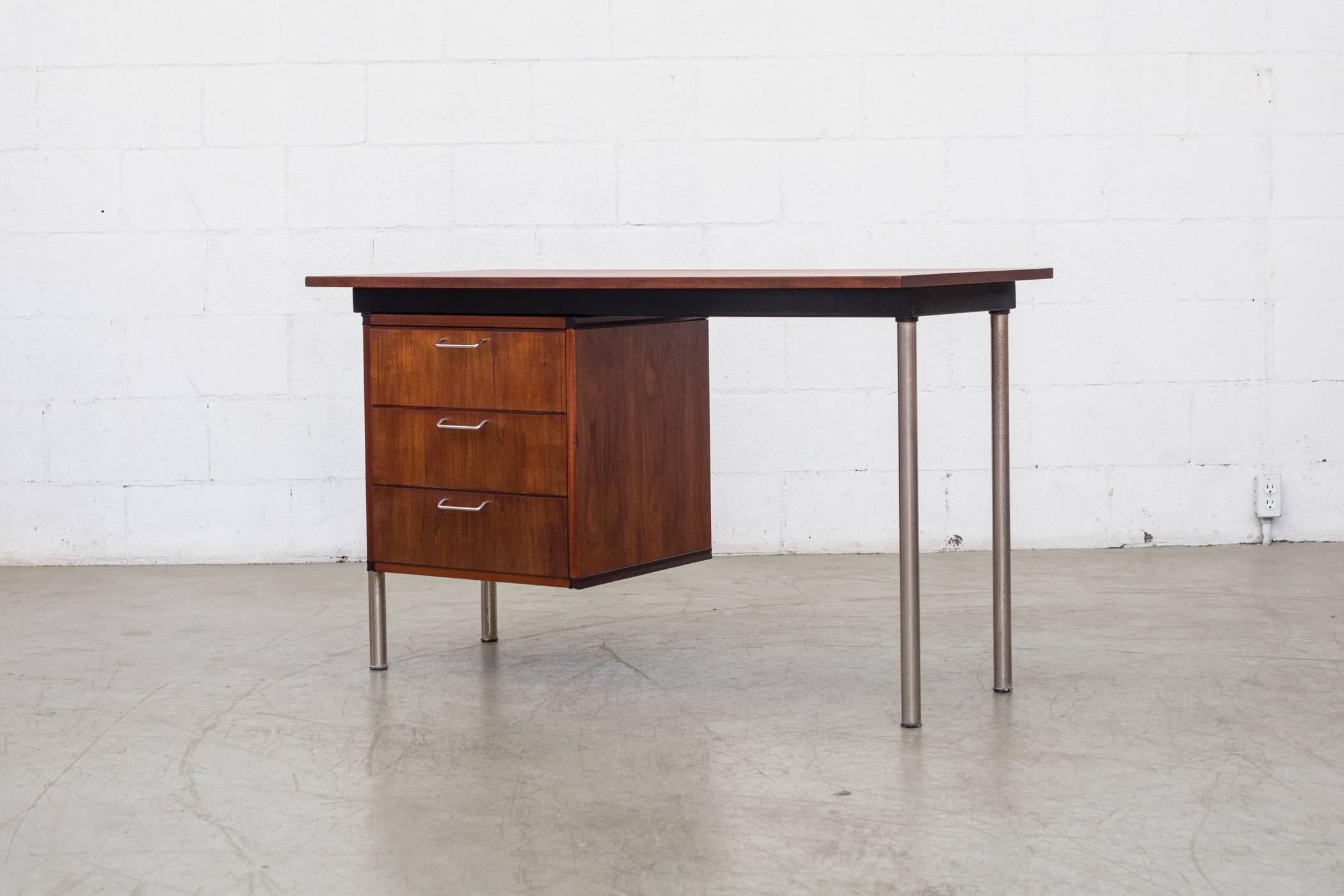 Part of Cees Braakman's 1956 made to measure series for Pastoe this small made to measure teak desk has three drawers with elegantly curved interiors, chrome legs and a decorative black accent. Original condition, wear consistent with age with