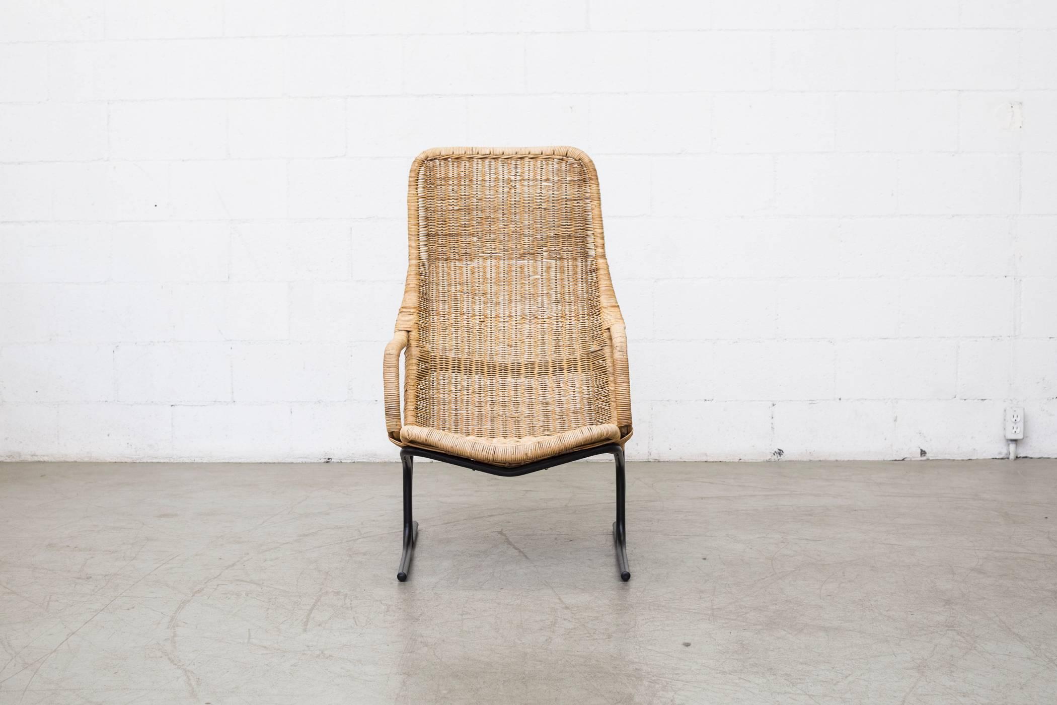 High back woven rattan lounge chair with black enameled metal tubular frame in original condition. Visible signs of wear, minimal rattan loss. Beautiful chair!