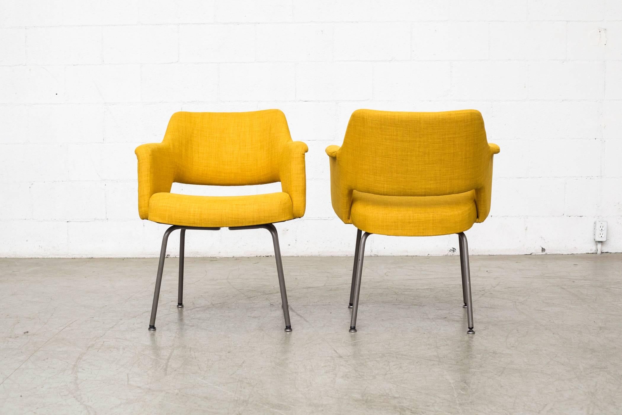 Pair of Saarinen style armchairs in new French mustard upholstery and grey enameled steel legs, in good original condition. Legs show signs of wear consistent with their age and usage. Set price.