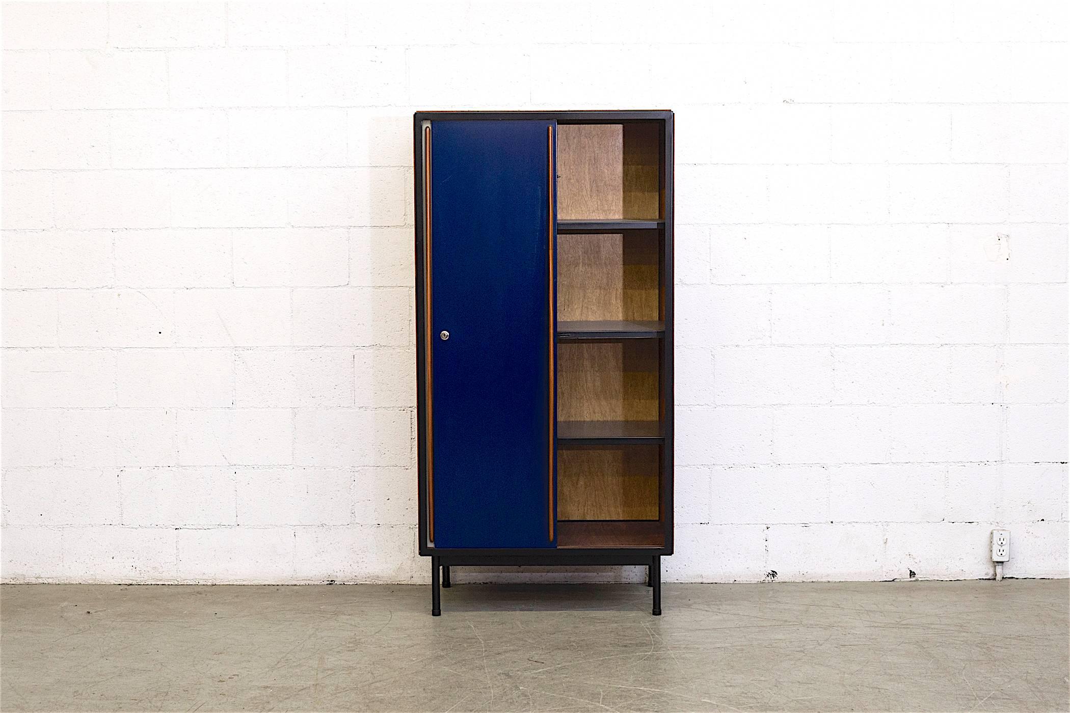 Rare Industrial wardrobe designed By Willy Van Der Meeren. Enameled metal two-toned sliding doors in light grey and dark blue with organic teak carved handles. Doors open to reveal one side of wardrobe space, enameled metal shelves on the other. The