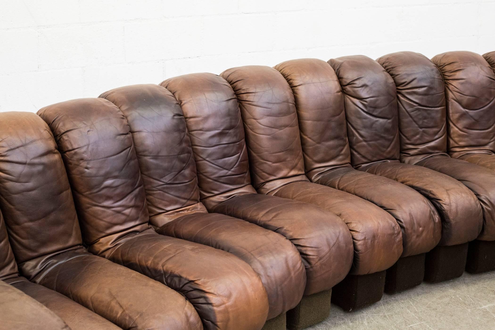 De Sede DS 600 “Non-Stop” sectional leather sofa by Heinz Ulrich, Ueli bergère and Elenora Peduzzi-Riva. Original worn brown leather seating with matching brown felt bases. 19 pieces, all of which hook and zip together. Felt in original worn