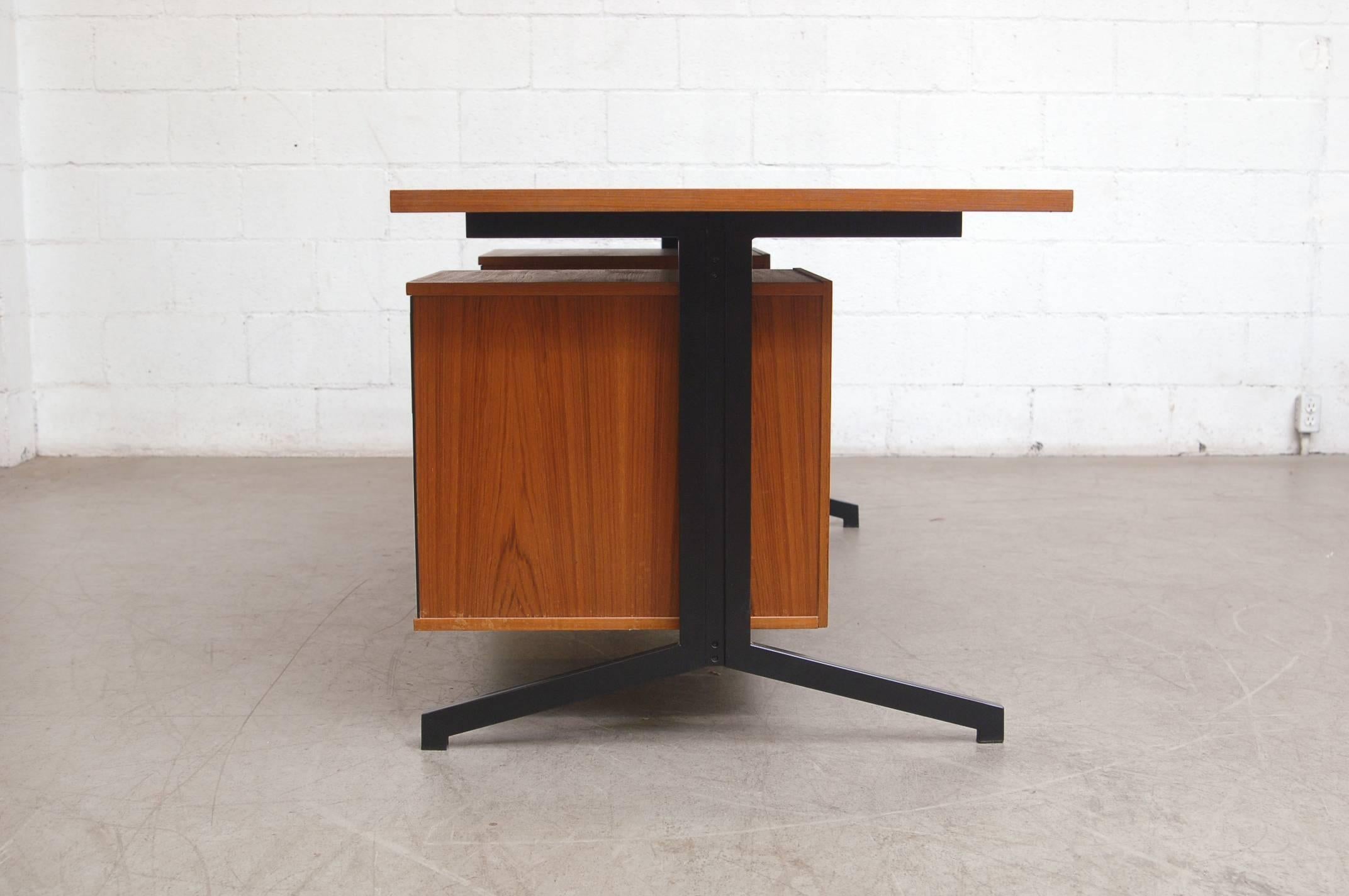 Large teak executive desk with Prouve style legs, black enameled metal frame and six drawers.