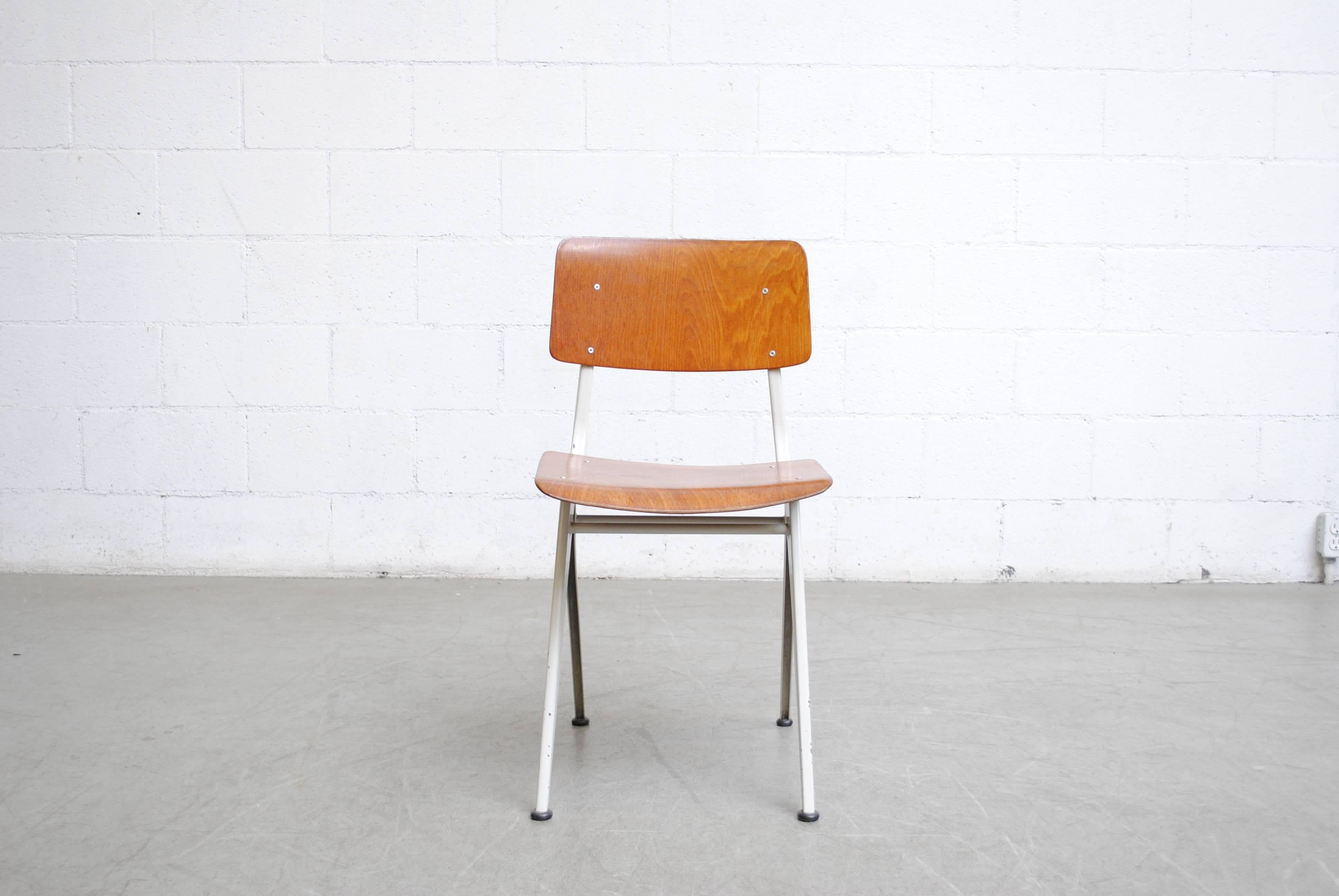 Industrial sheet metal frame in light grey with teak toned plywood seat and back. Visible wear consistent with their age and usage.
