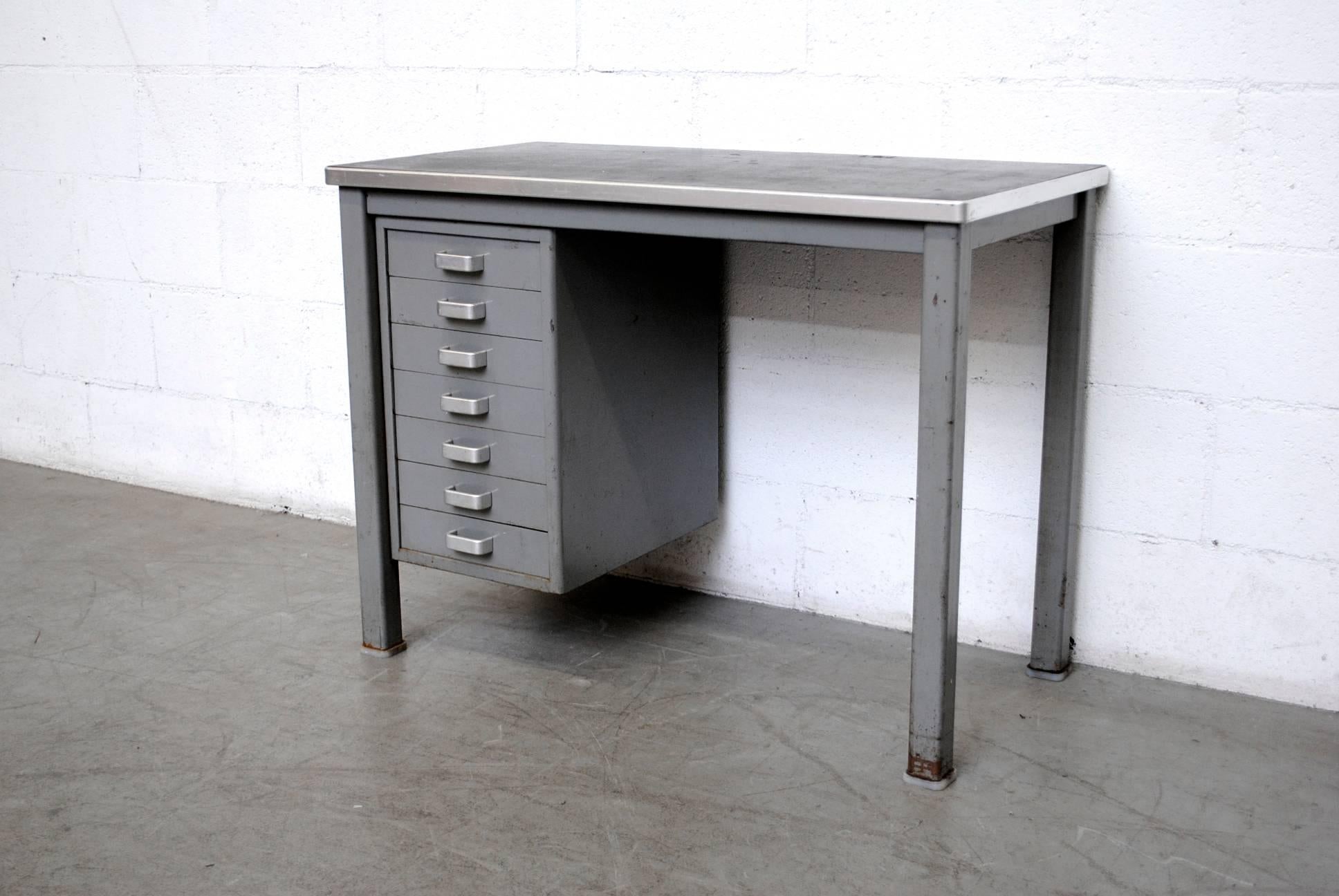 Minimalist Industrial desk with grey metal frame and original Linoleum top. 7 drawers with brushed chrome hand pulls. Metal horseshoe foot caps.