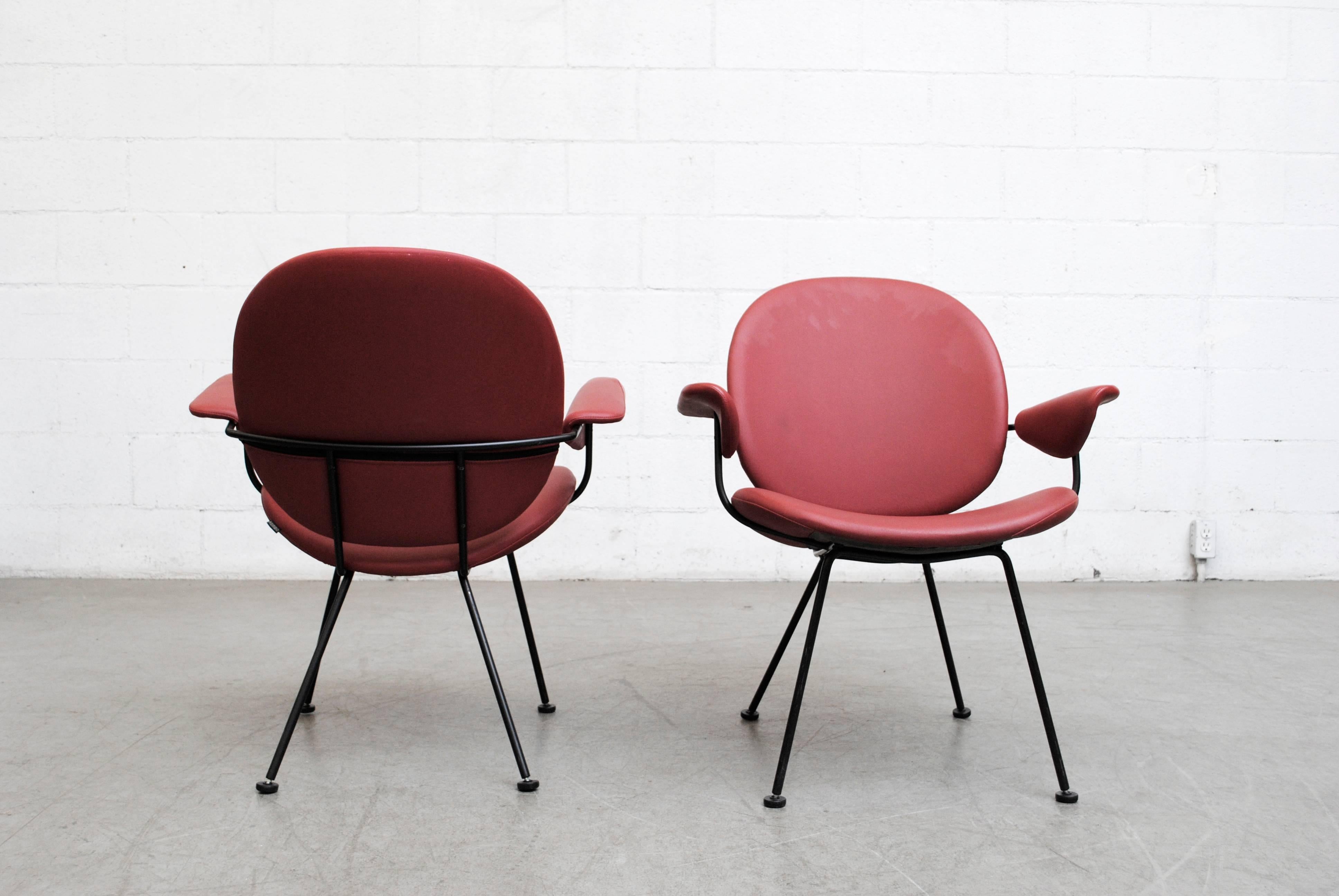 Set of two armchairs by Kembo (Attributed to Wm. Rietveld). Original dark red upholstery with Kembo Tag. Black enameled metal wire frames and original feet.