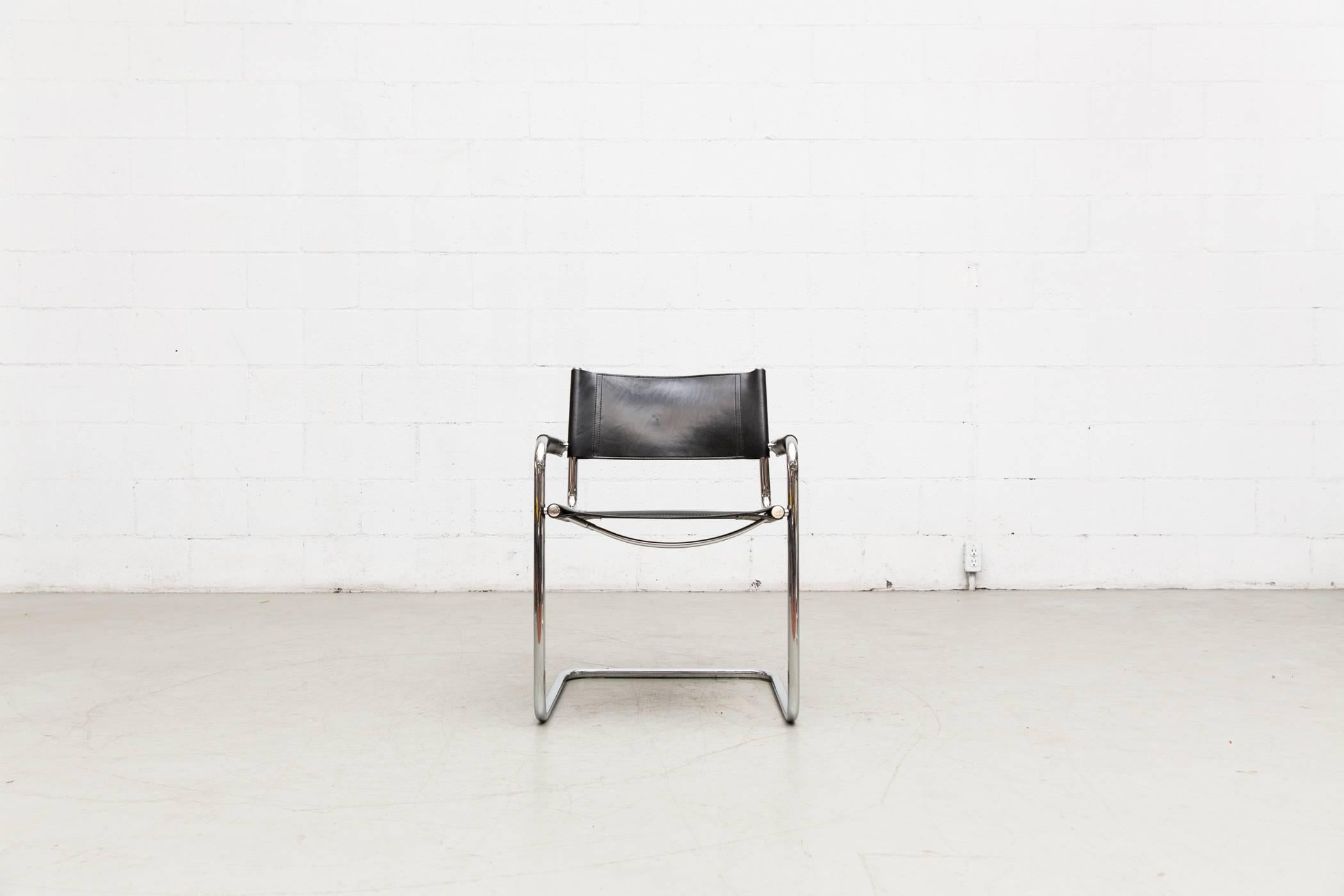 Black leather Marcel Breuer style cantilevered armchair with chrome frame. Original condition with visible scratching and wear. Leather wrapped armrests secured with a screw. Original condition. Some variations, also some variations and levels of