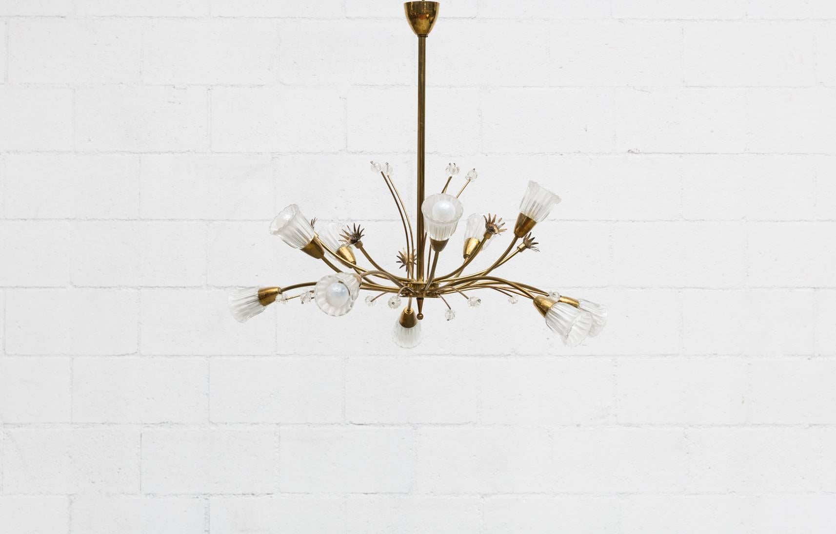 Hollywood Regency style brass floral spray chandelier with heavy pressed glass shades. Mini brass floral sprays have miniature light bulbs, some are missing. Original condition. Brass shows some discoloration and visible patina.
