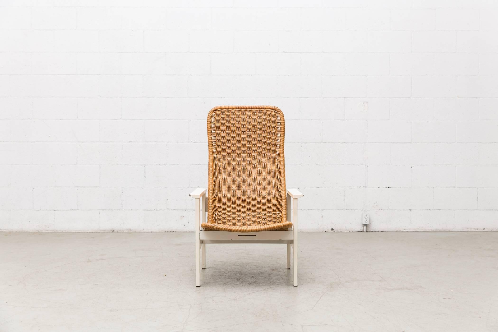 Elegantly woven Dirk Van Sliedregt rattan high back lounge chair with white wood frame and arm rests. Visible signs of wear consistent with its age and usage. Other similar styles available and listed separately.