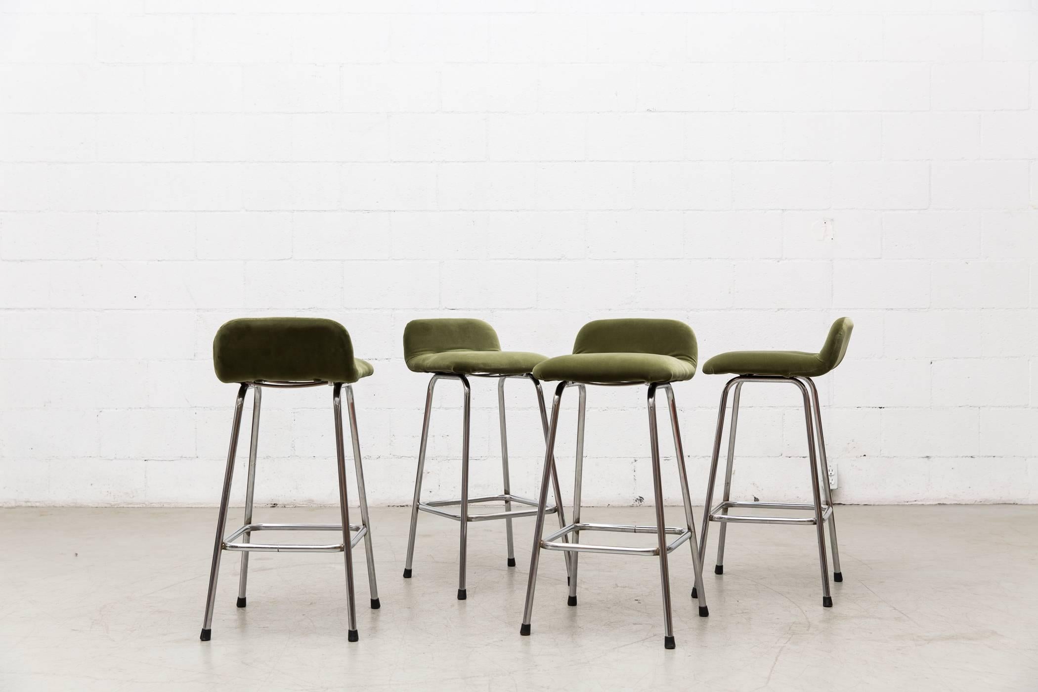 Set of four chrome bar stools with seats newly upholstered in olive green velvet. Frames are in original condition with visible signs of wear. Set price.